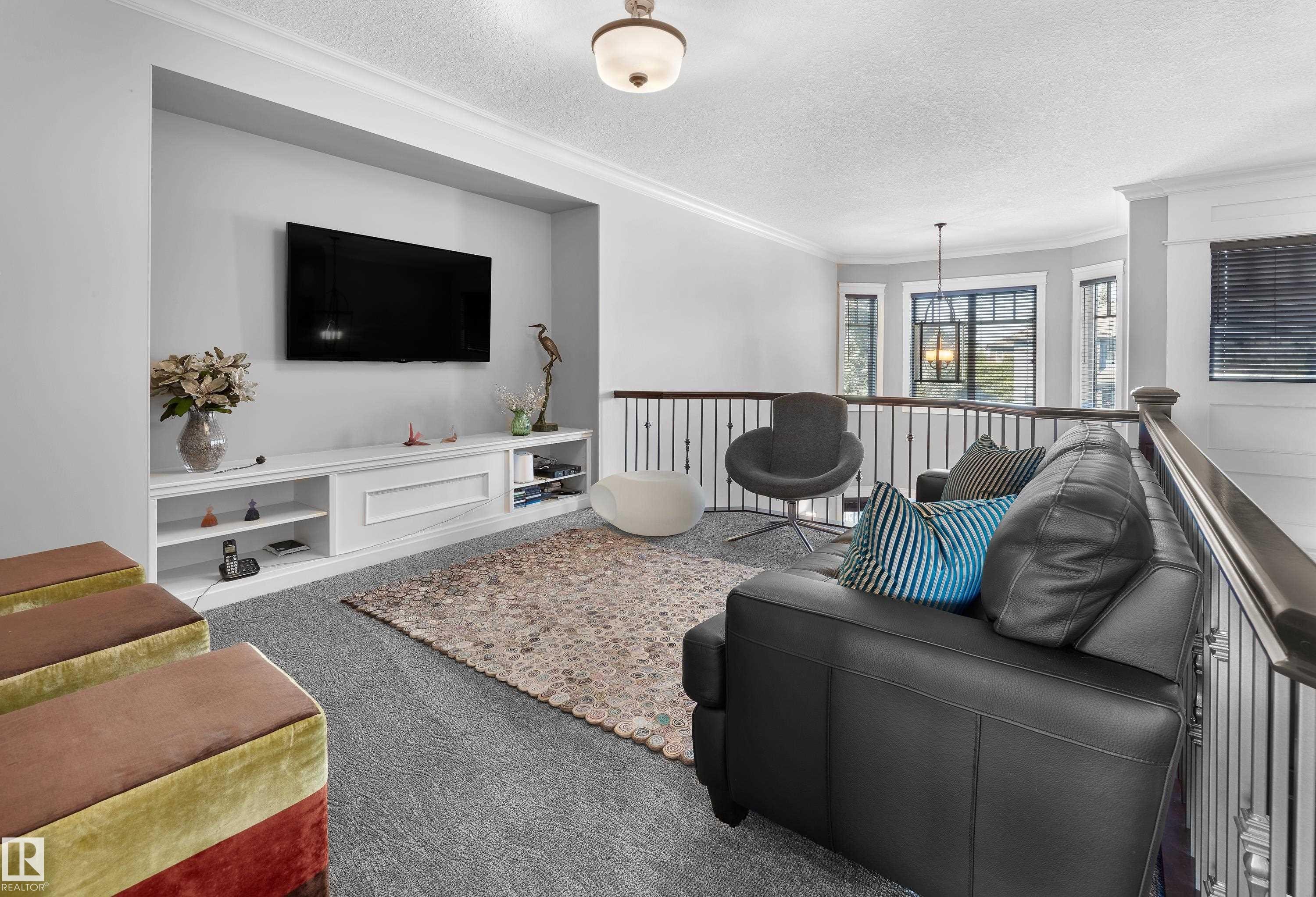 Carpeted living area featuring crown molding, a textured ceiling, and a chandelier - 4111 Westcliff Heath Heath, Edmonton, AB - Indoor Photo Showing Living Room