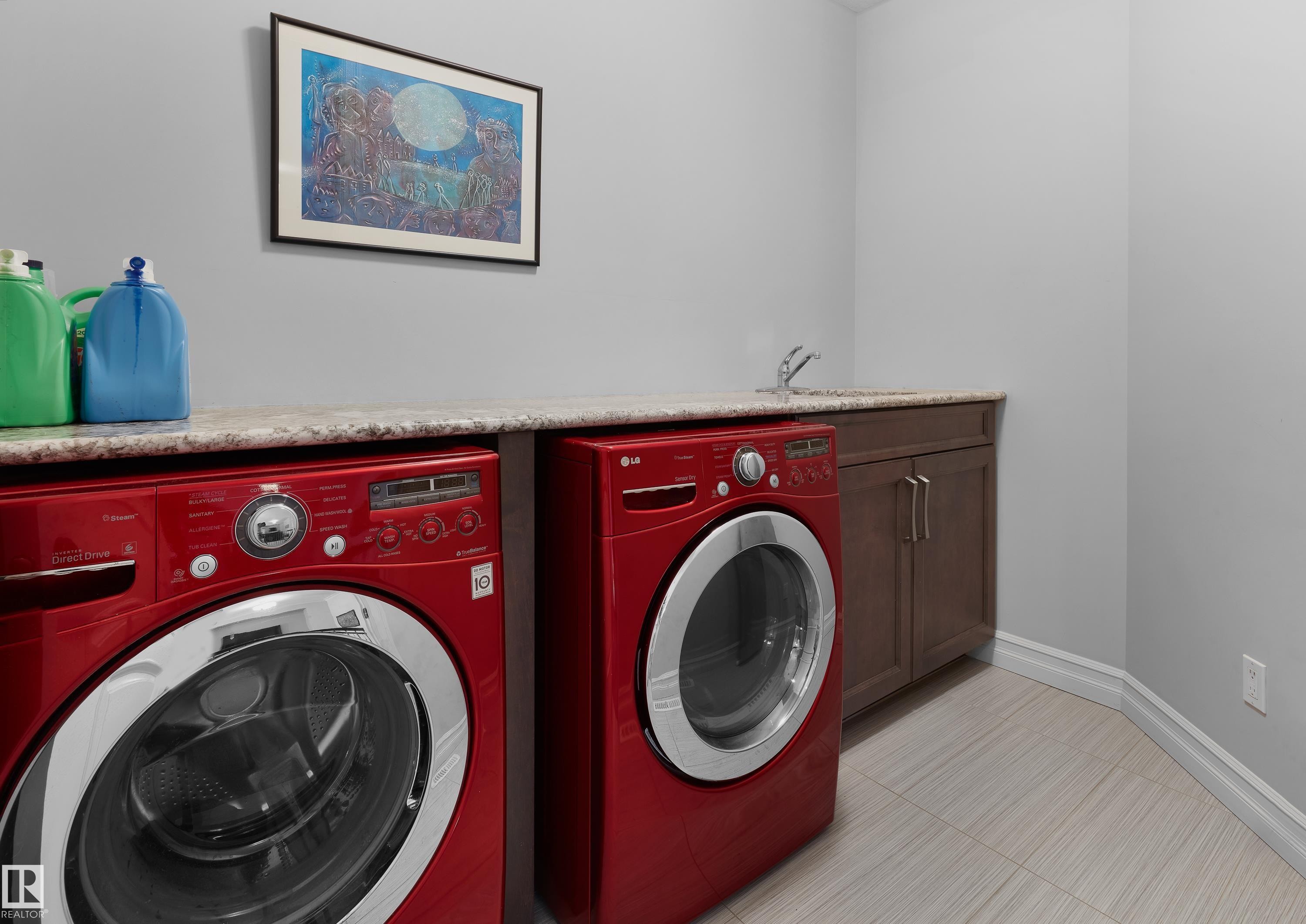 Laundry area with washer and dryer, cabinet space, and light tile patterned floors - 4111 Westcliff Heath Heath, Edmonton, AB - Indoor Photo Showing Laundry Room