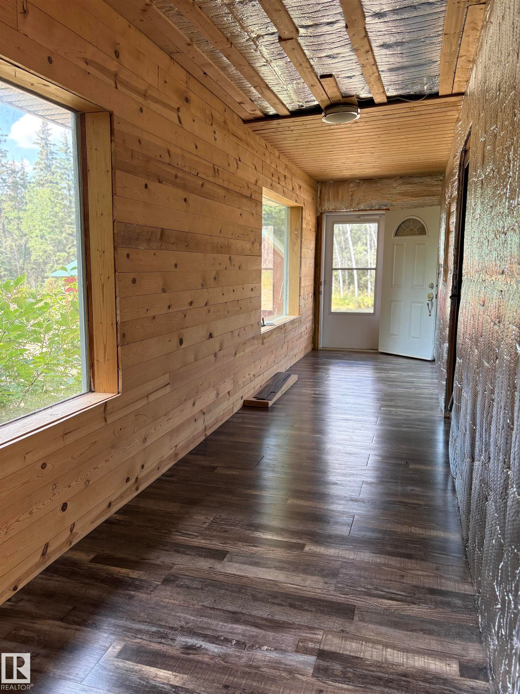 Empty room with wooden walls and dark wood-style floors - B58018 Hiway 29, Rural St. Paul County, AB - Indoor Photo Showing Other Room