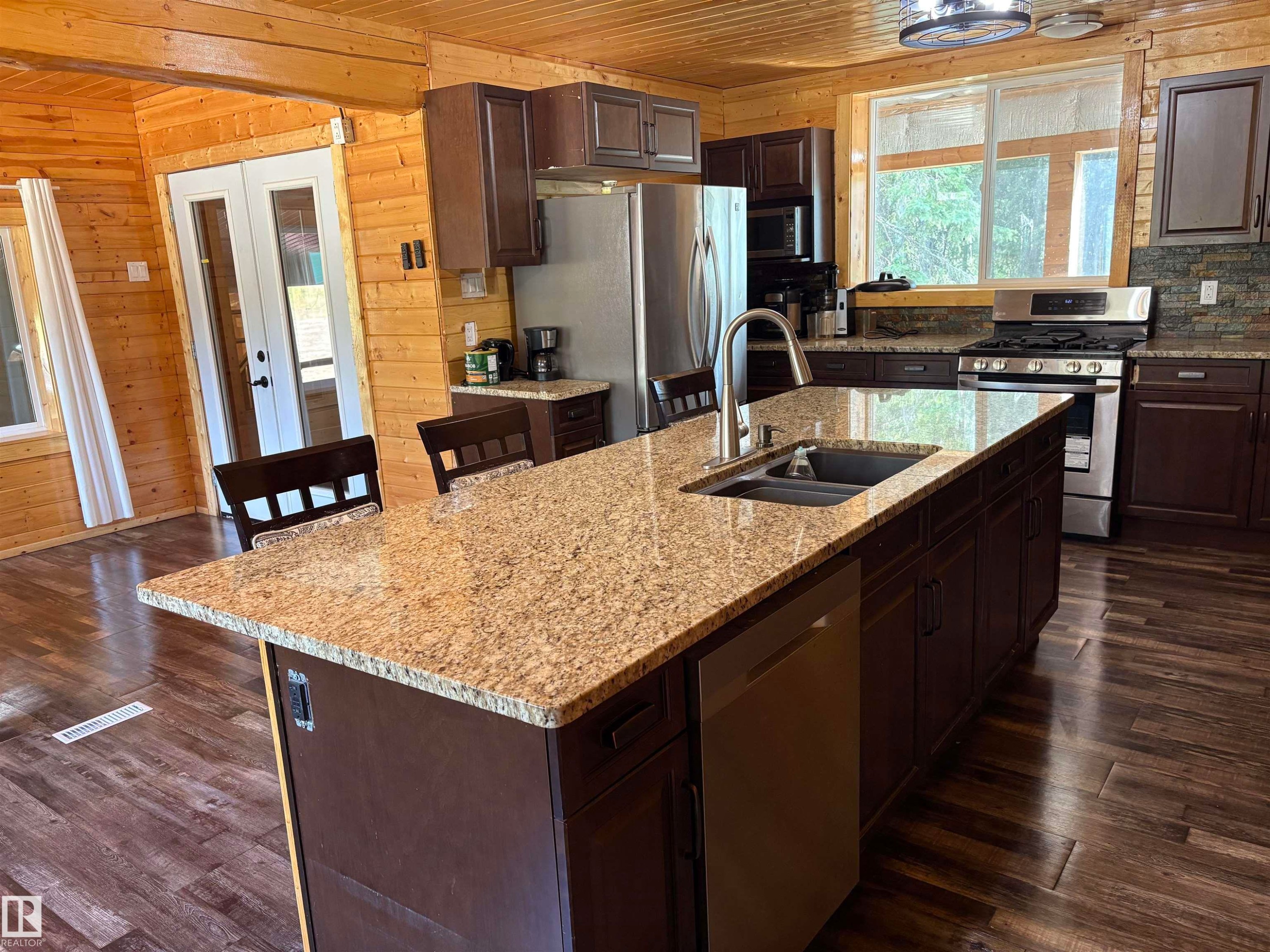 Kitchen island with dishwasher and eat up counter. - B58018 Hiway 29, Rural St. Paul County, AB - Indoor Photo Showing Kitchen With Double Sink