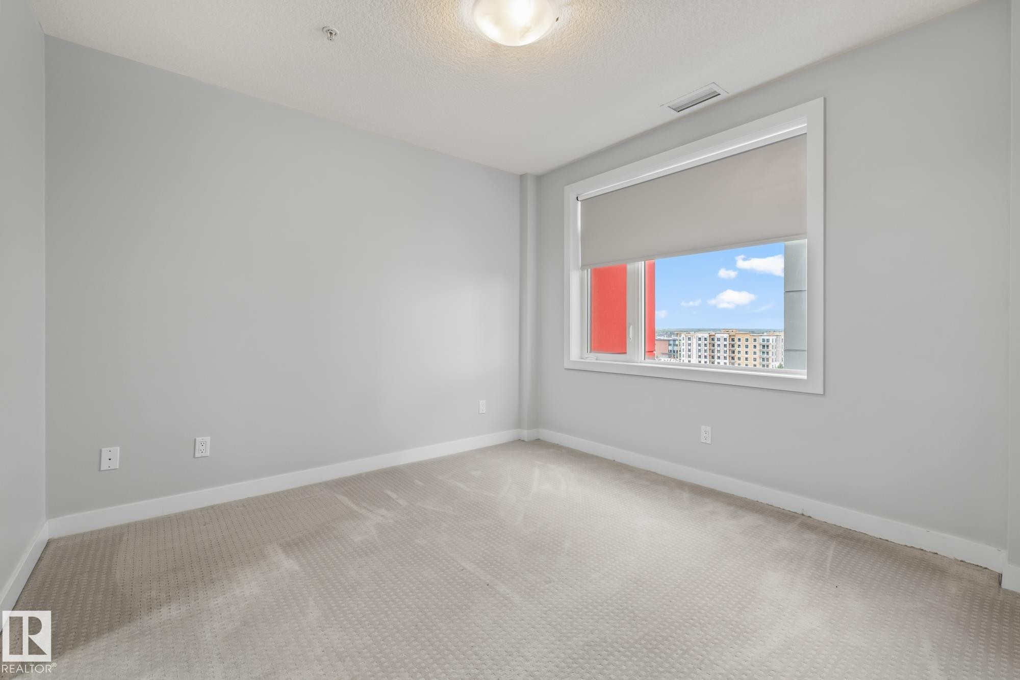 Spare room featuring carpet flooring and a textured ceiling - 810 5151 Windermere Boulevard, Edmonton, AB - Indoor Photo Showing Other Room