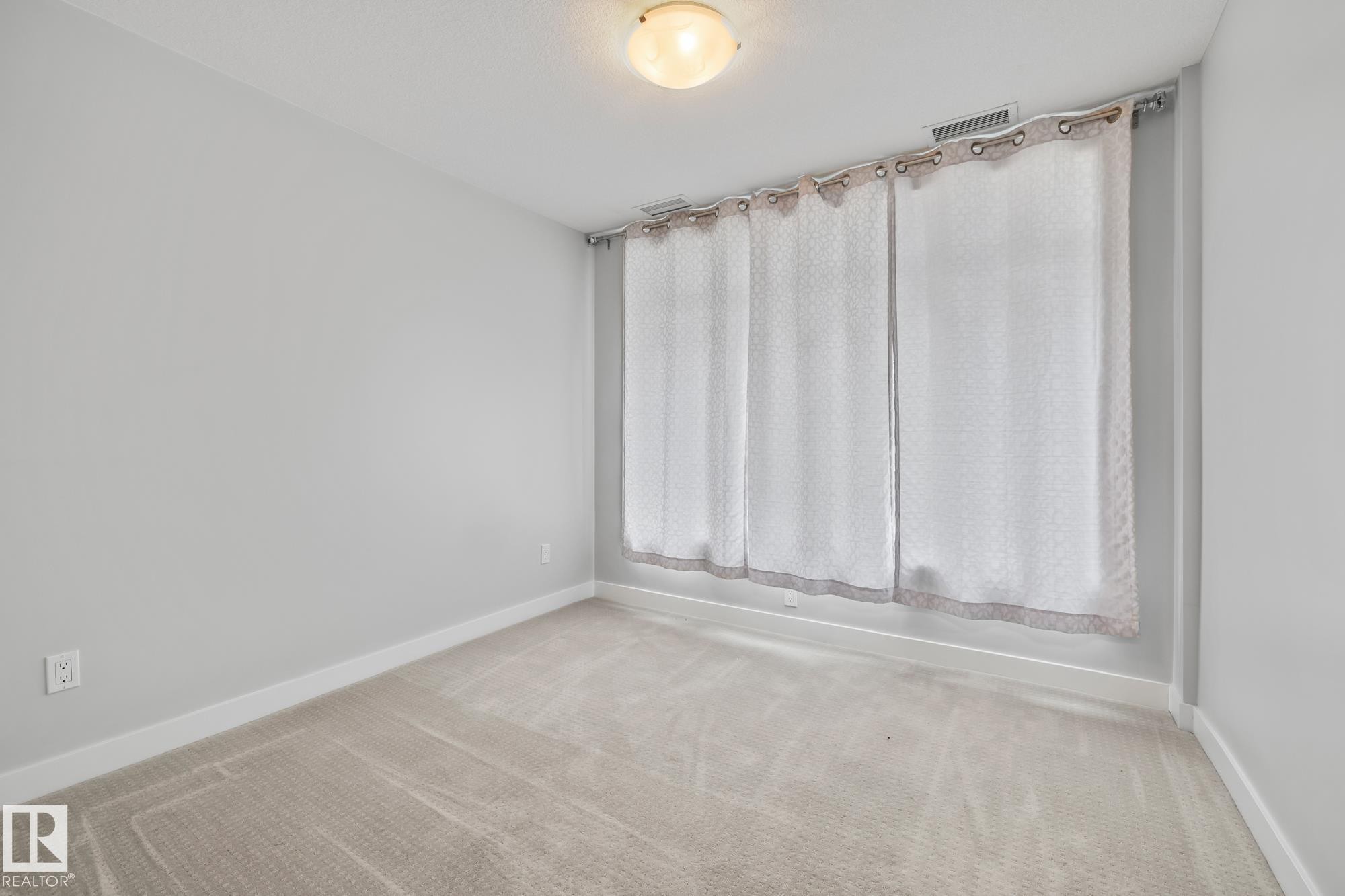 Carpeted spare room with baseboards - 810 5151 Windermere Boulevard, Edmonton, AB - Indoor Photo Showing Other Room