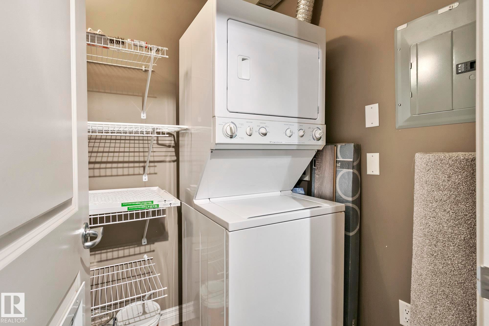 The laundry area features a white stacked washer and dryer, along with white wire shelving for storage - 334 10121 80 Avenue, Edmonton, AB - Indoor Photo Showing Laundry Room