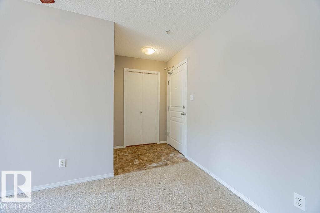 Corridor with a textured ceiling and light colored carpet - Edmonton, AB - Indoor Photo Showing Other Room