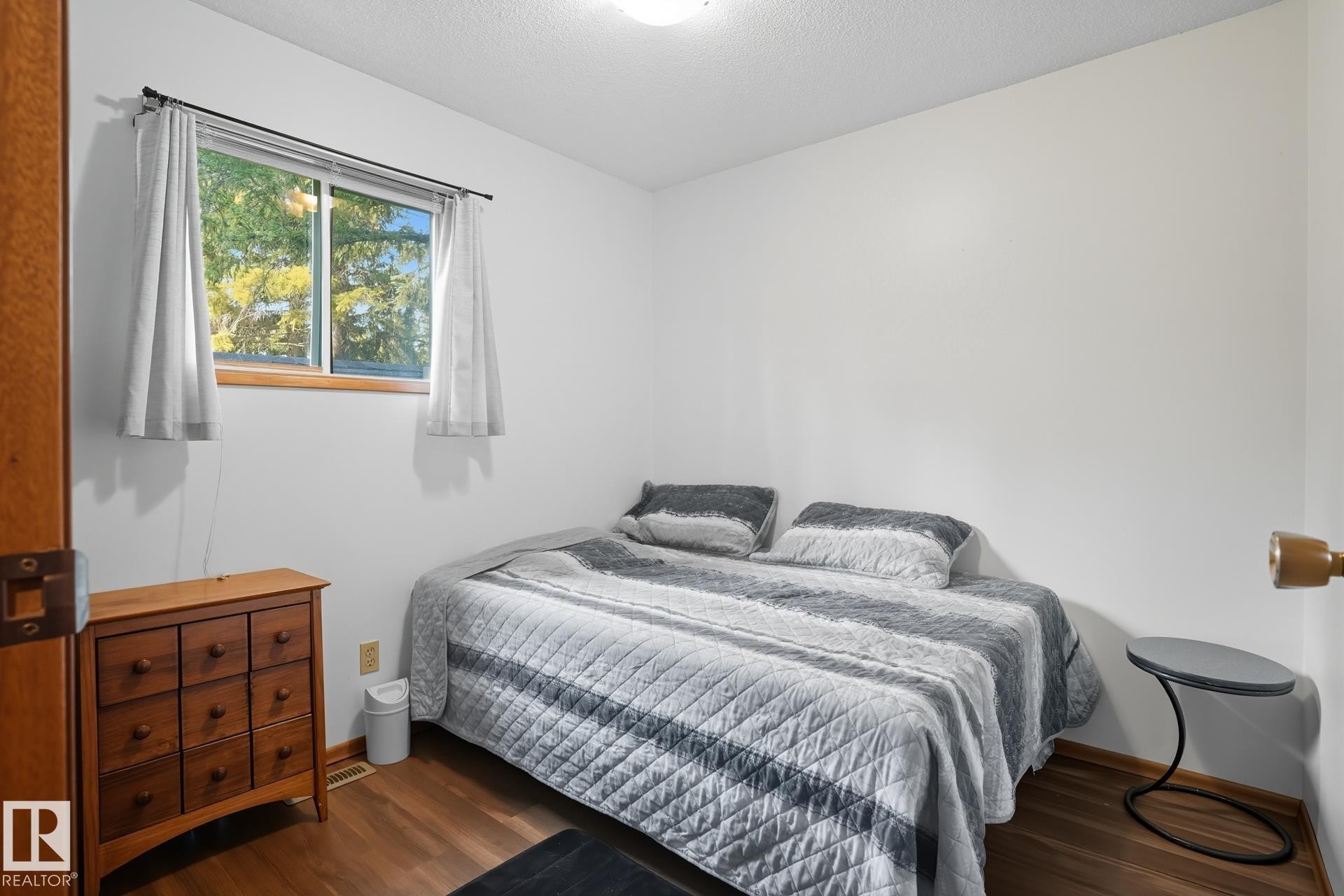 Bedroom with wood finished floors and a textured ceiling - 6309 49 St, Rural Wetaskiwin County, AB - Indoor Photo Showing Bedroom
