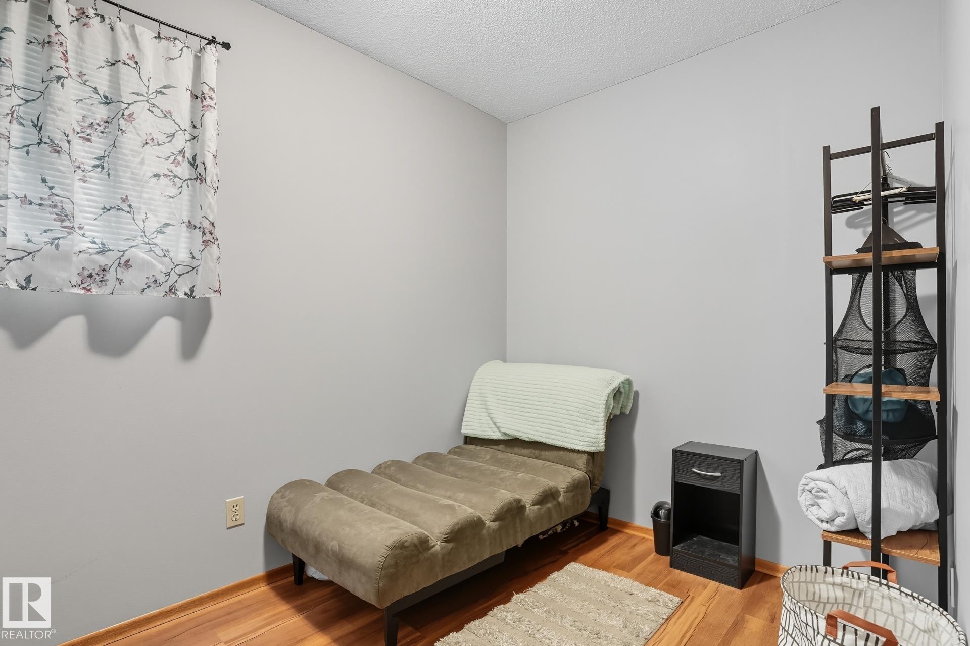 Living area with wood finished floors and a textured ceiling - 6309 49 St, Rural Wetaskiwin County, AB - Indoor