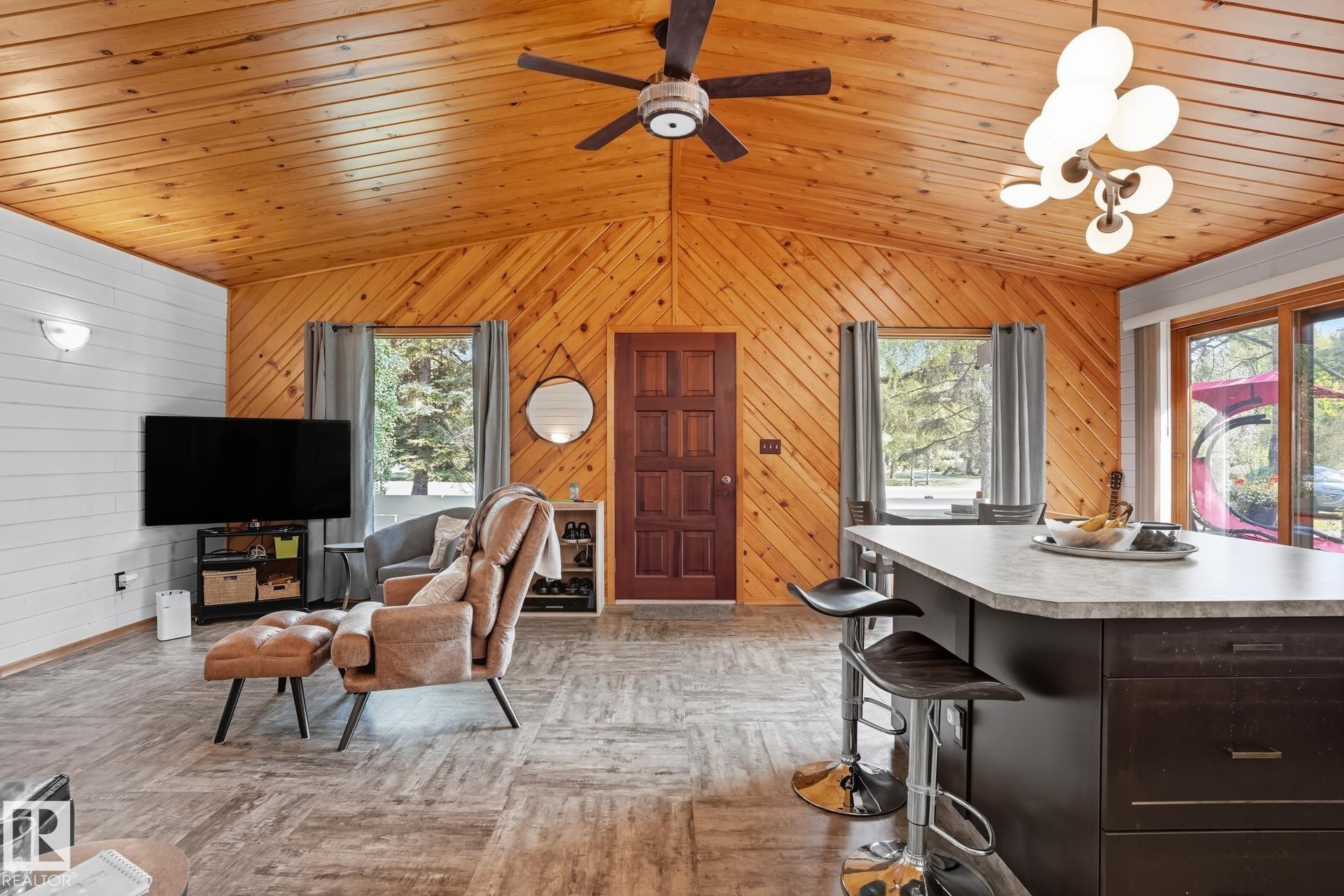 Living room with wood walls, lofted ceiling, wooden ceiling, and ceiling fan - 6309 49 St, Rural Wetaskiwin County, AB - Indoor
