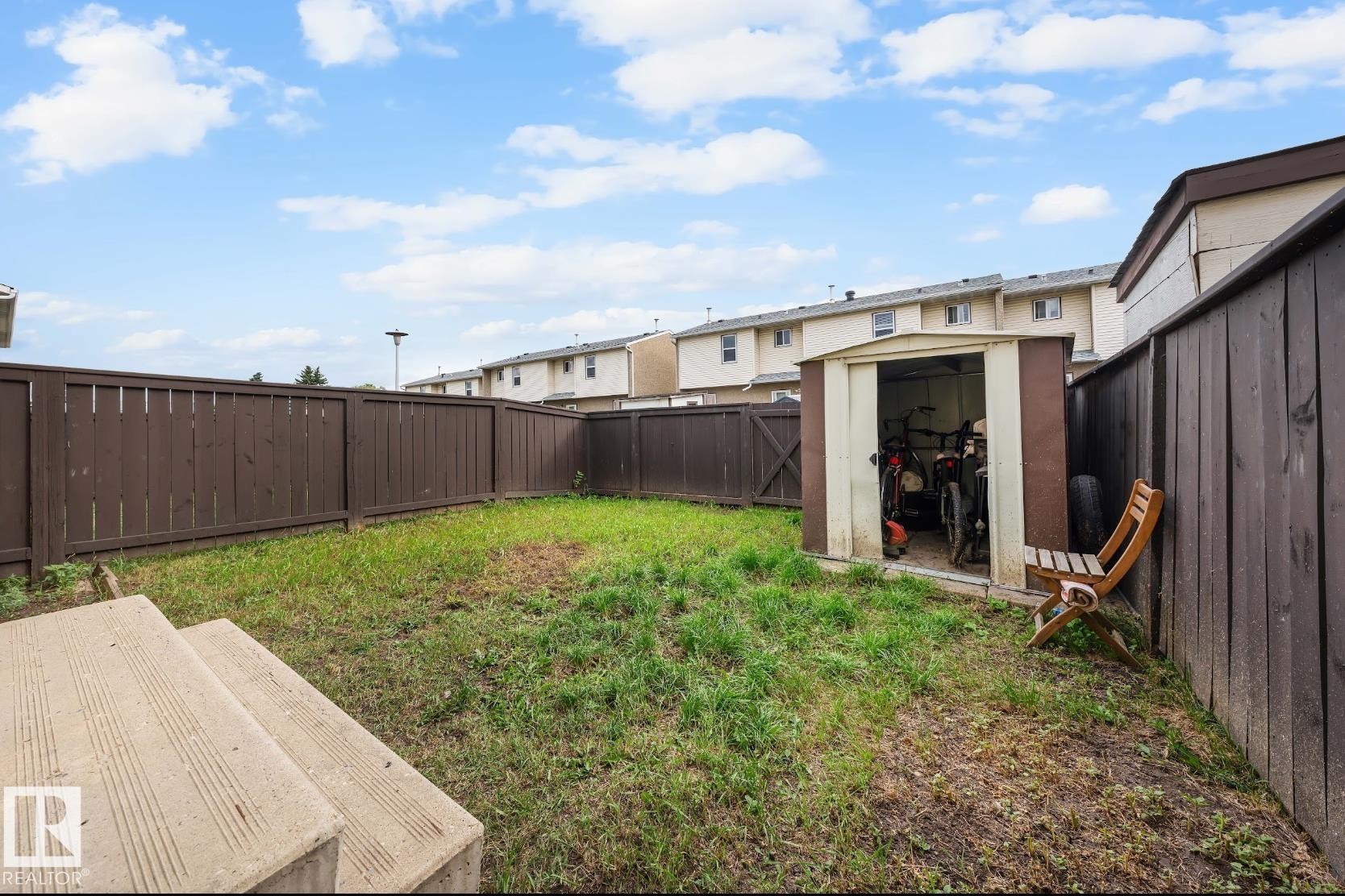 Fenced backyard featuring a storage unit and a patio area - 285 Harrison Drive, Edmonton, AB - Outdoor