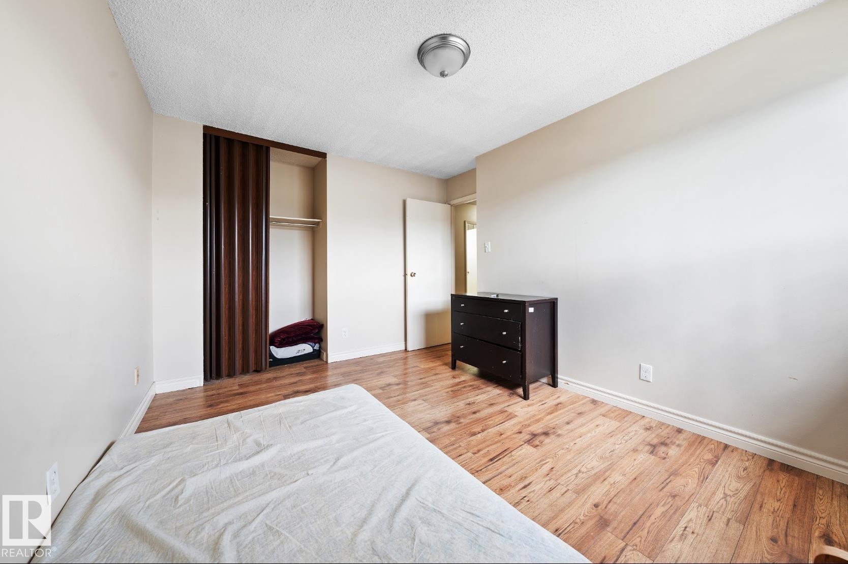 Bedroom featuring wood finished floors, a closet, and a textured ceiling - 285 Harrison Drive, Edmonton, AB - Indoor Photo Showing Bedroom