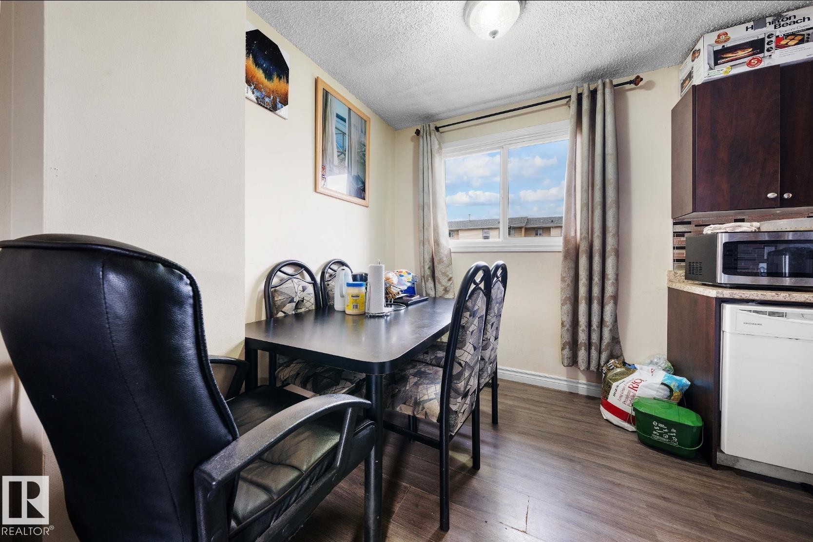 Dining room featuring dark wood-style floors, a textured ceiling, and an office area - 285 Harrison Drive, Edmonton, AB - Indoor