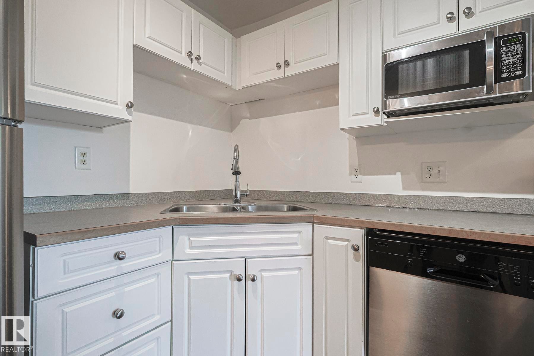 Kitchen with stainless steel appliances and white cabinets - 120 7511 171 Street Nw, Edmonton, AB - Indoor Photo Showing Kitchen With Double Sink