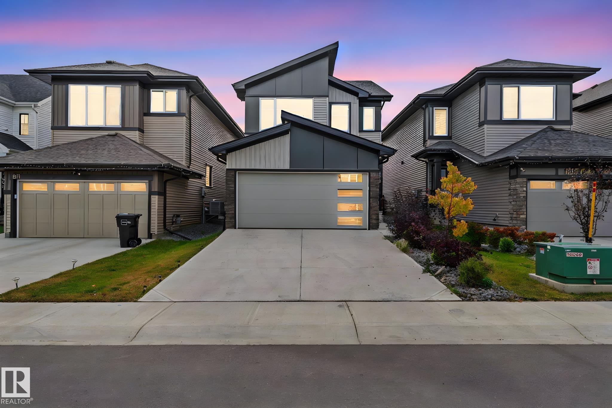 Contemporary home with a garage, concrete driveway, and board and batten siding - 1813 Collip View View, Edmonton, AB - Outdoor