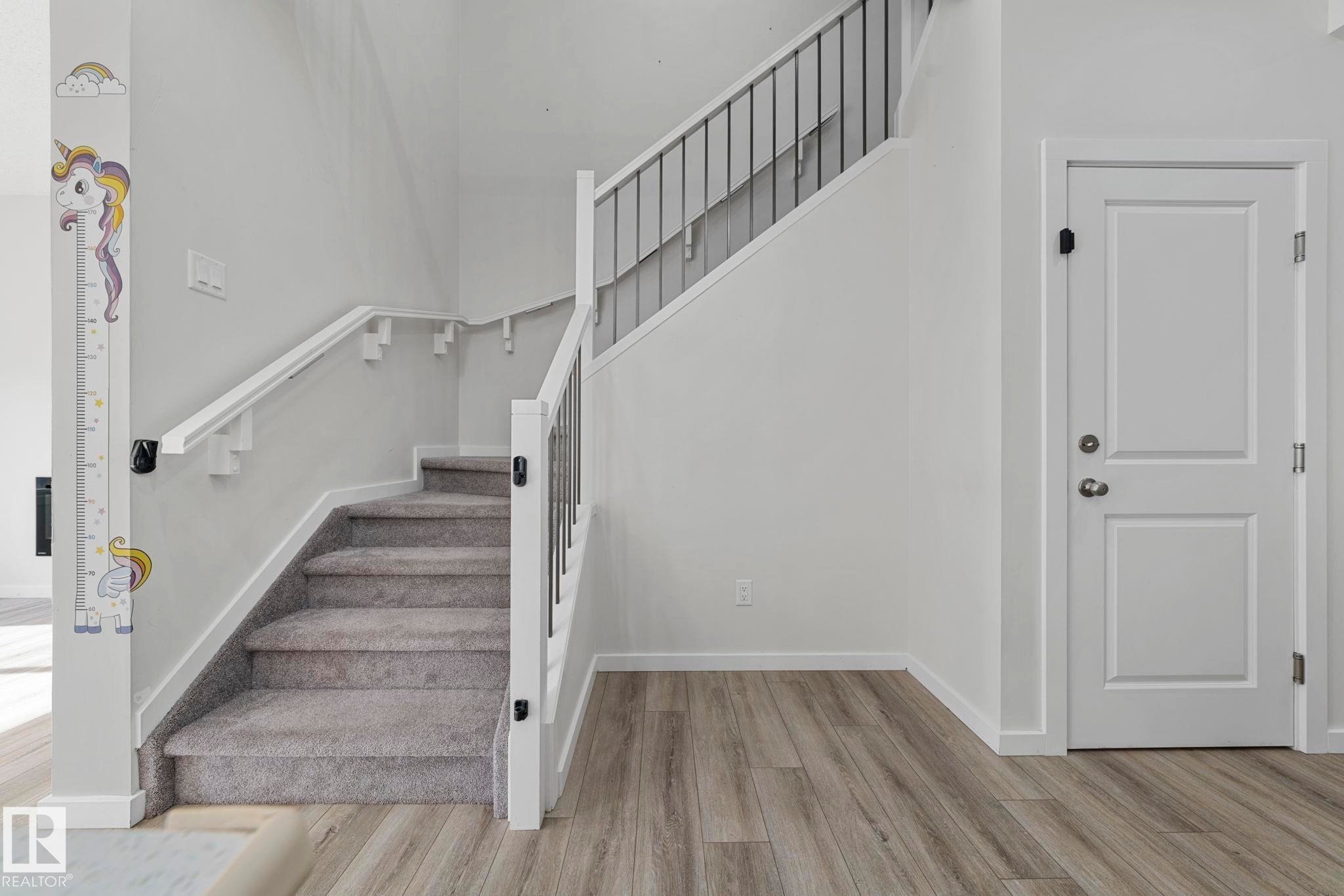 Staircase featuring wood finished floors and baseboards - 1813 Collip View View, Edmonton, AB - Indoor Photo Showing Other Room