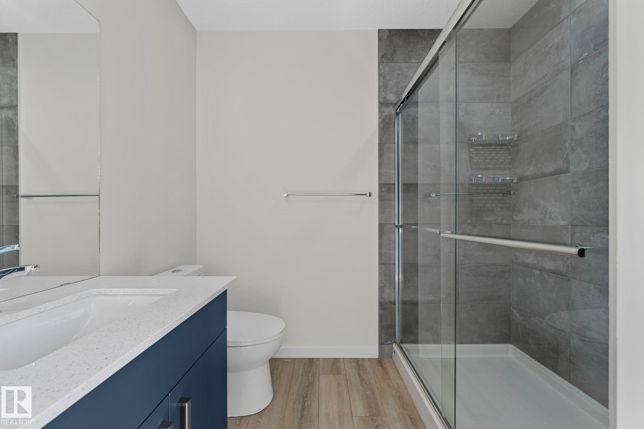 Full bathroom featuring vanity, a stall shower, and light wood-type flooring - 1813 Collip View View, Edmonton, AB - Indoor Photo Showing Bathroom