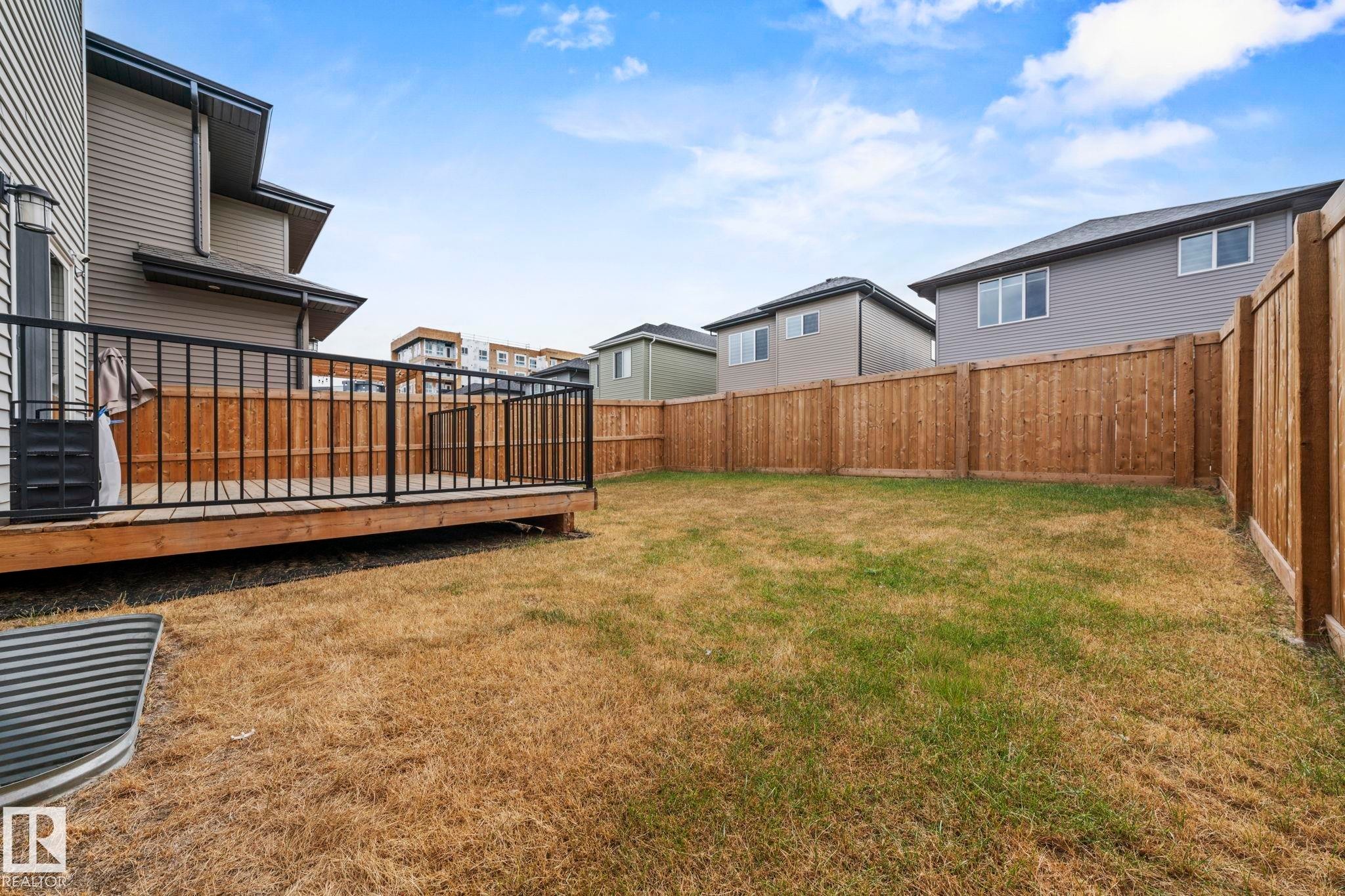 Fenced backyard with a deck and a residential view - 1813 Collip View View, Edmonton, AB - Outdoor With Exterior