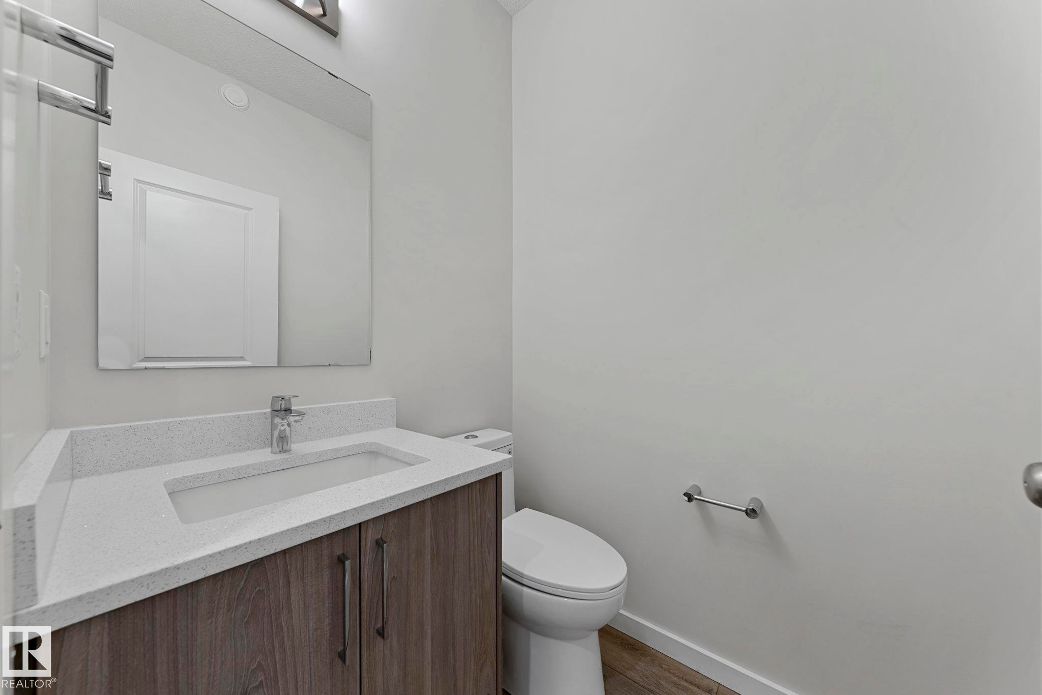 Half bathroom with vanity and wood finished floors - 1813 Collip View View, Edmonton, AB - Indoor Photo Showing Bathroom