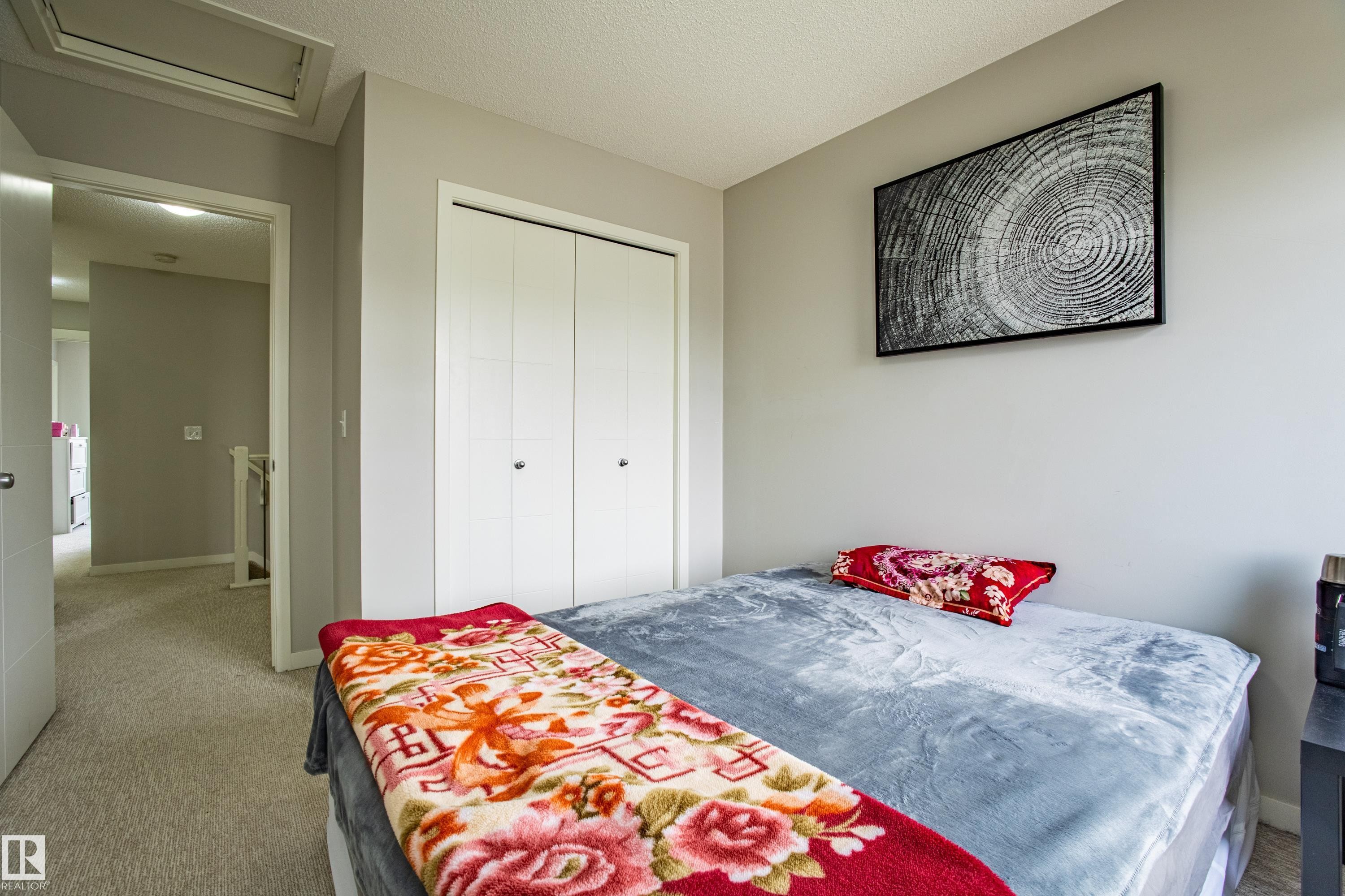 Carpeted bedroom with a textured ceiling, a closet, and attic access - 2407 Casey Link, Edmonton, AB - Indoor Photo Showing Bedroom