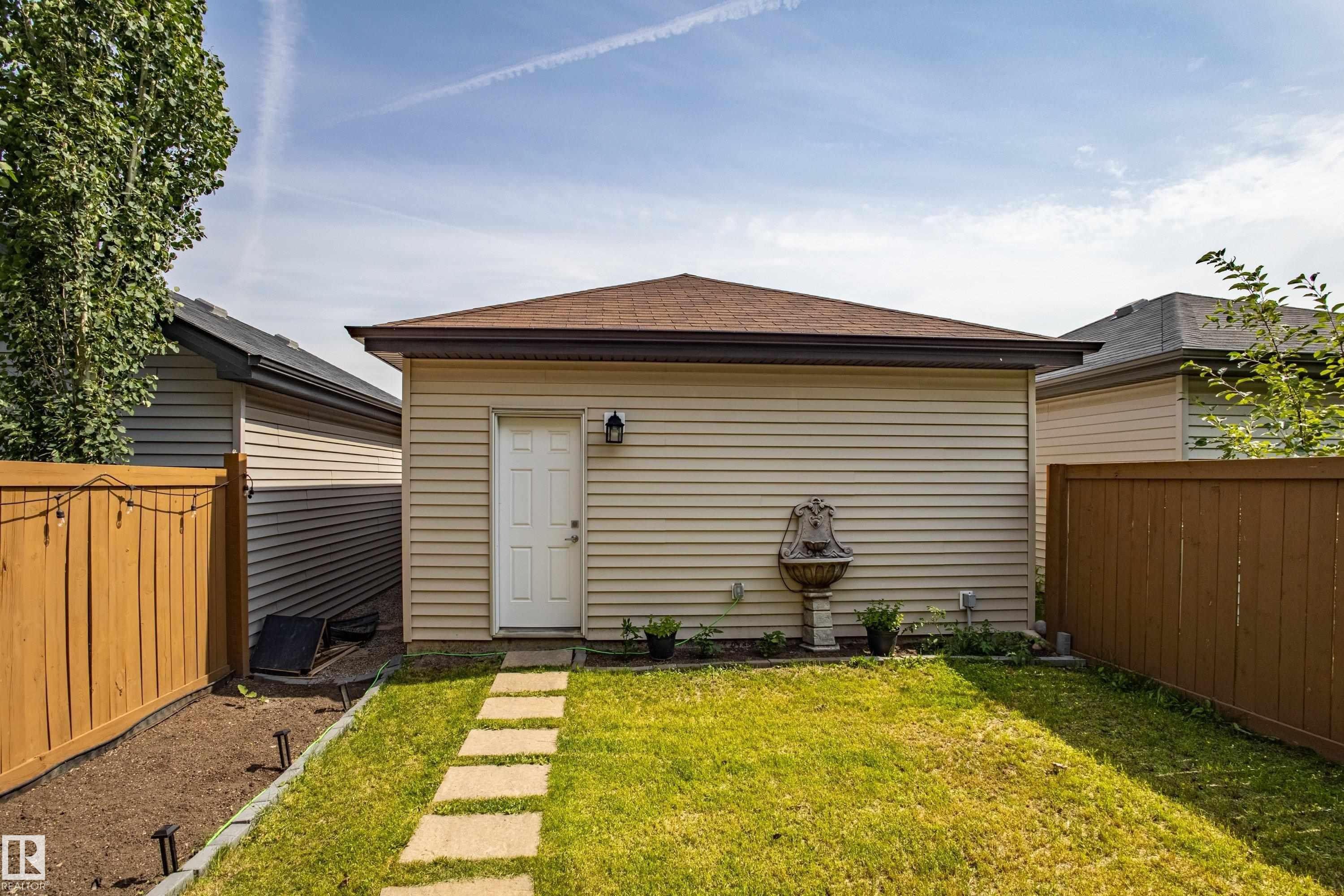 Back of house featuring a fenced backyard and roof with shingles - 2407 Casey Link, Edmonton, AB - Outdoor With Exterior