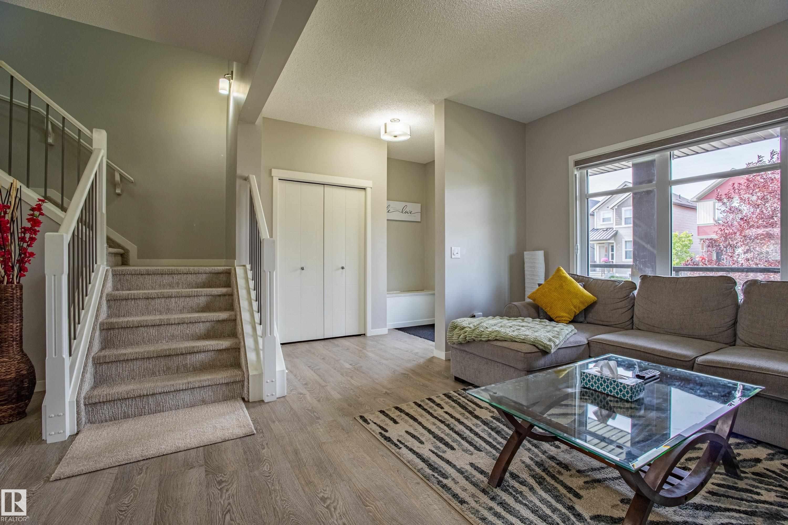 Living room featuring stairs, wood finished floors, and a textured ceiling - 2407 Casey Link, Edmonton, AB - Indoor Photo Showing Living Room