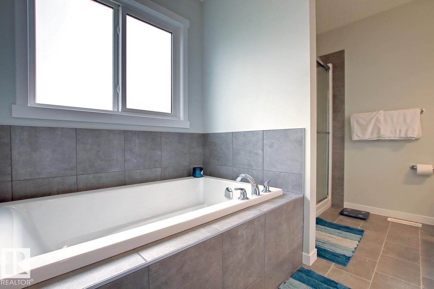 Bathroom featuring a garden tub, tile patterned flooring, and a shower stall - 19633 26A Av, Edmonton, AB - Indoor Photo Showing Bathroom