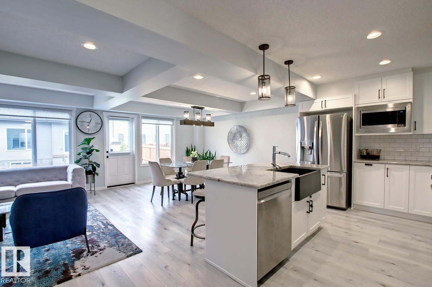 Kitchen featuring appliances with stainless steel finishes, light wood-style flooring, white cabinetry, light stone counters, and beam ceiling - 19633 26A Av, Edmonton, AB - Indoor Photo Showing Kitchen With Upgraded Kitchen
