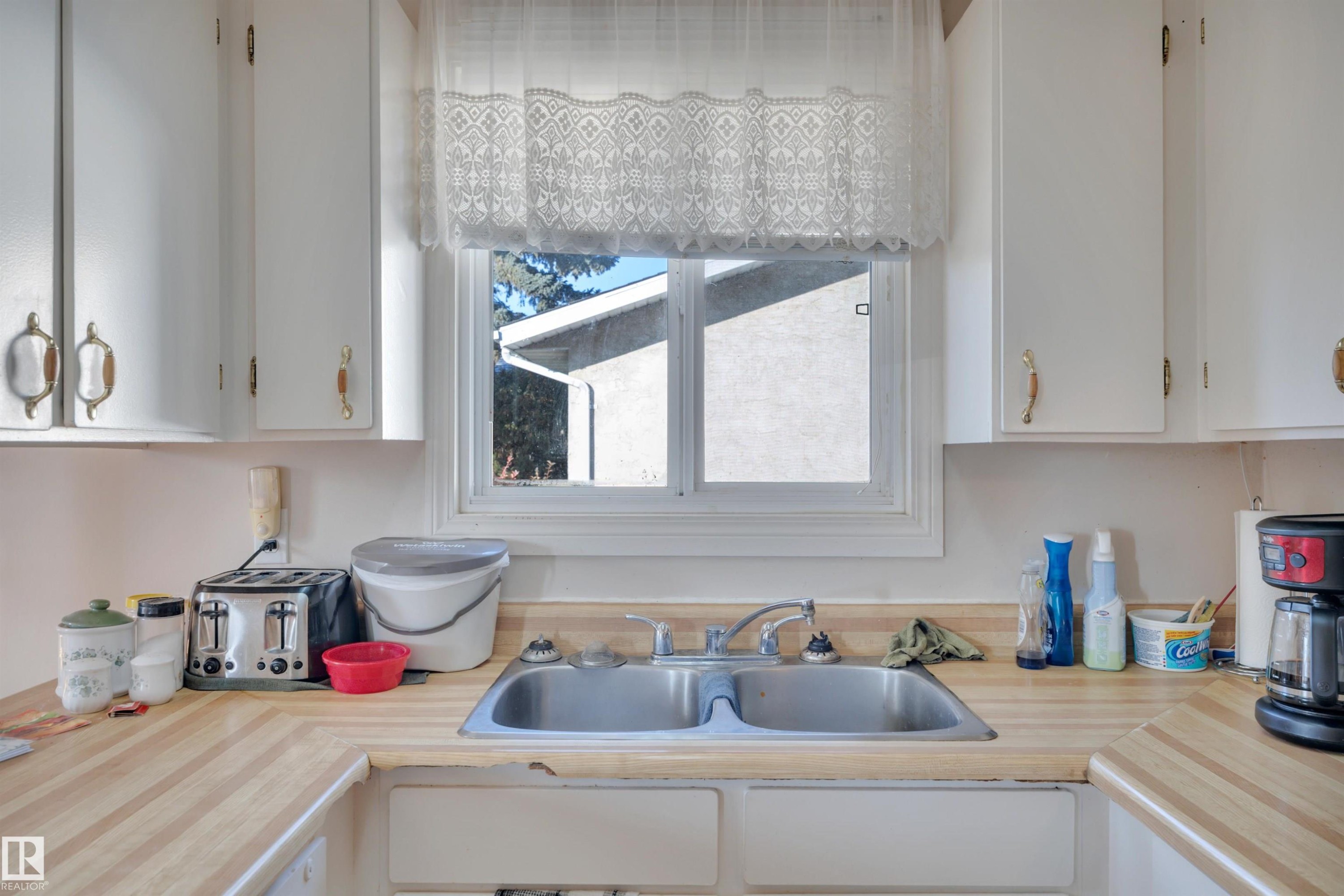 Kitchen featuring light countertops and white cabinets - 5312 36 Ave, Wetaskiwin, AB - Indoor Photo Showing Kitchen With Double Sink