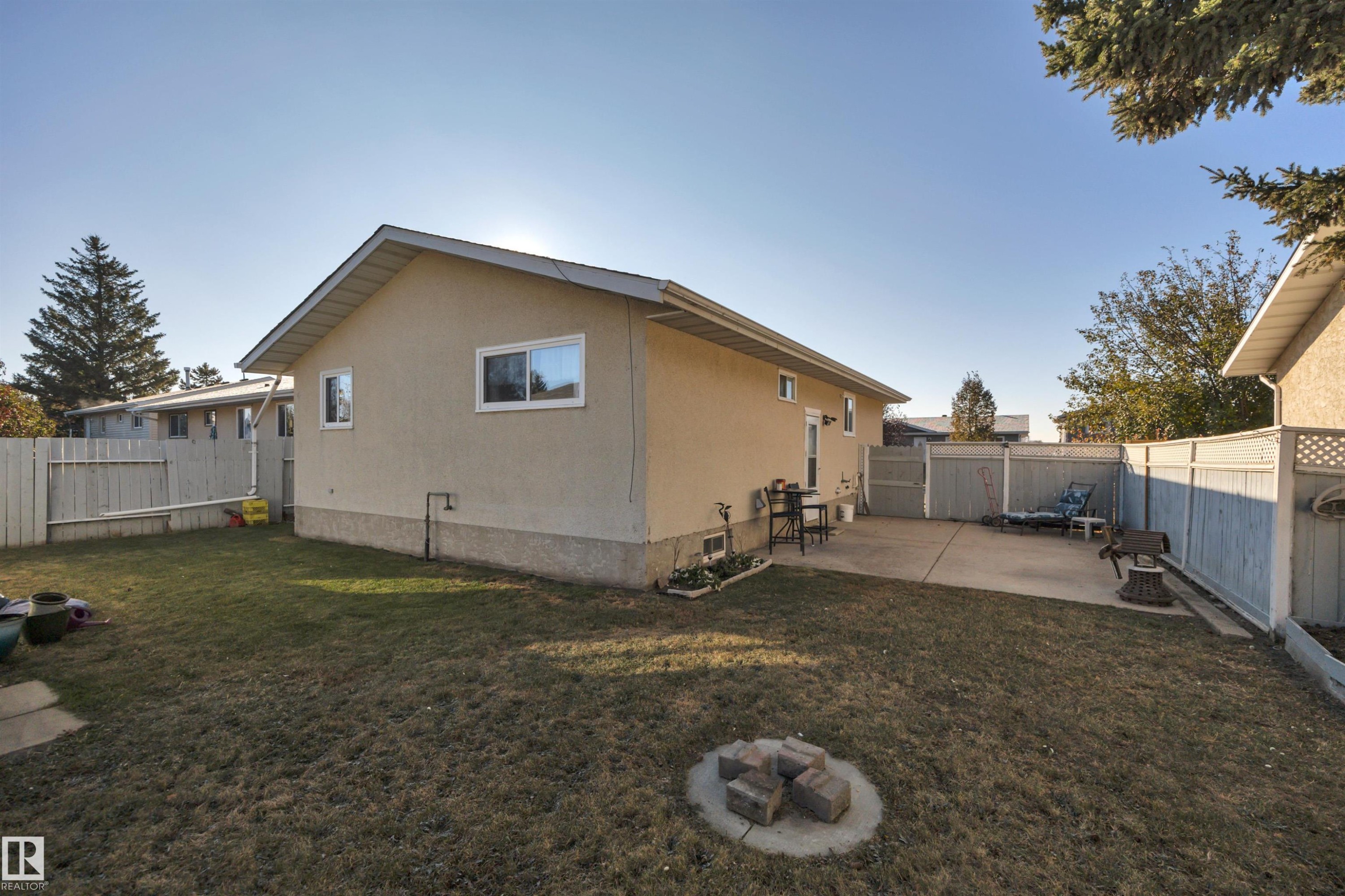 View of side of property featuring a fenced backyard, a patio area, and a fire pit - 5312 36 Ave, Wetaskiwin, AB - Outdoor With Exterior