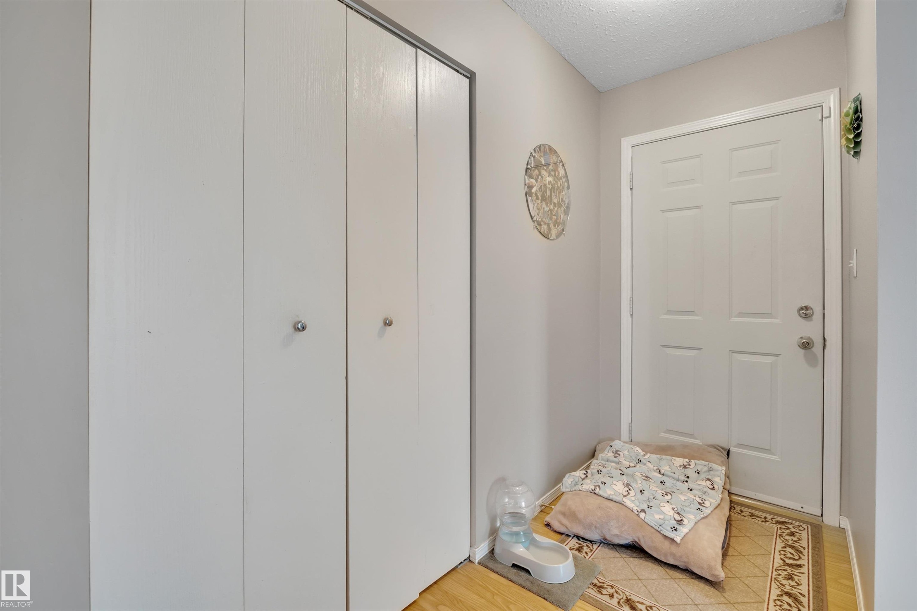 Entryway featuring a textured ceiling and wood finished floors - 5312 36 Ave, Wetaskiwin, AB - Indoor
