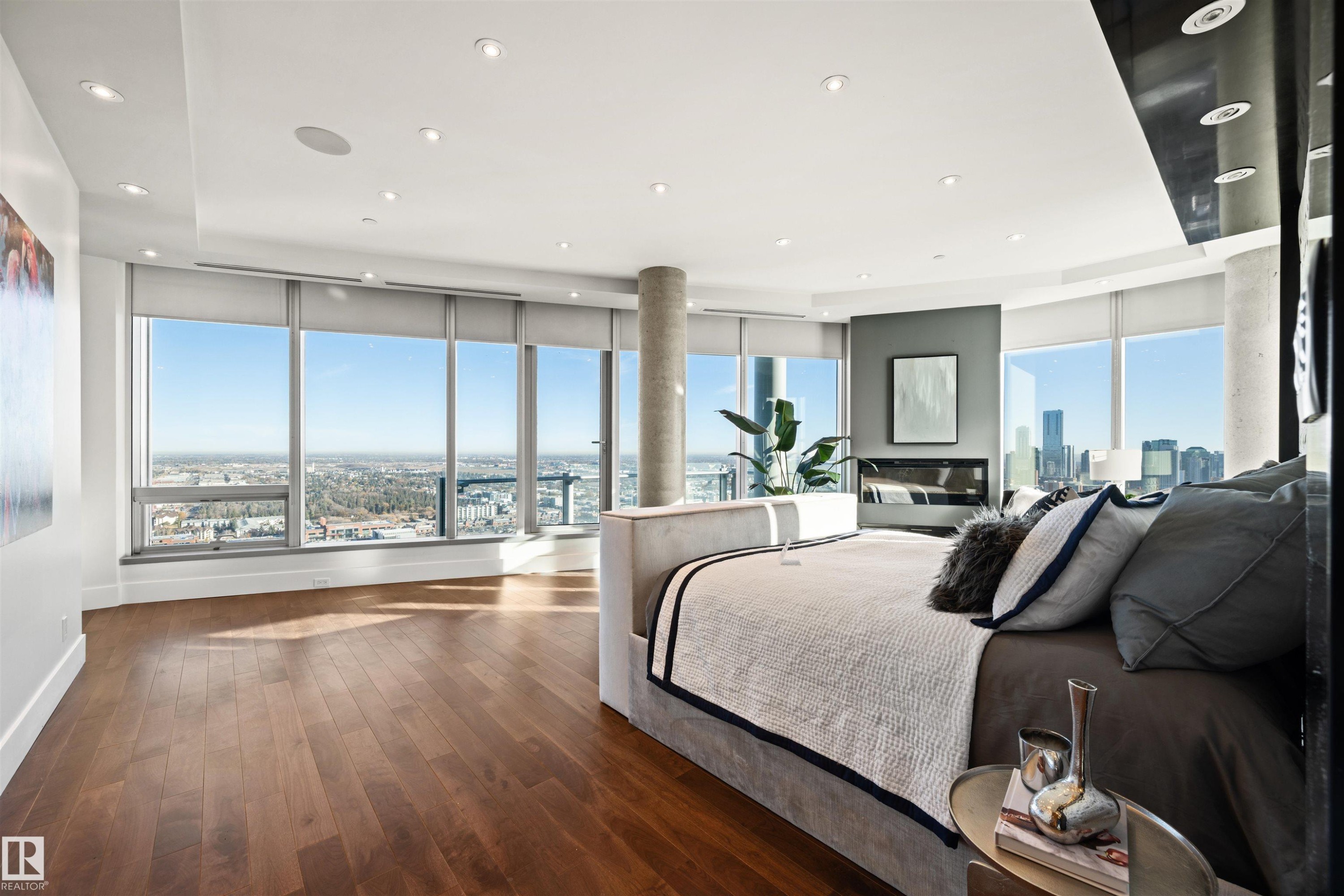Bedroom featuring dark wood finished floors, multiple windows, recessed lighting, and a city view - 3201 11969 Jasper Avenue, Edmonton, AB - Indoor