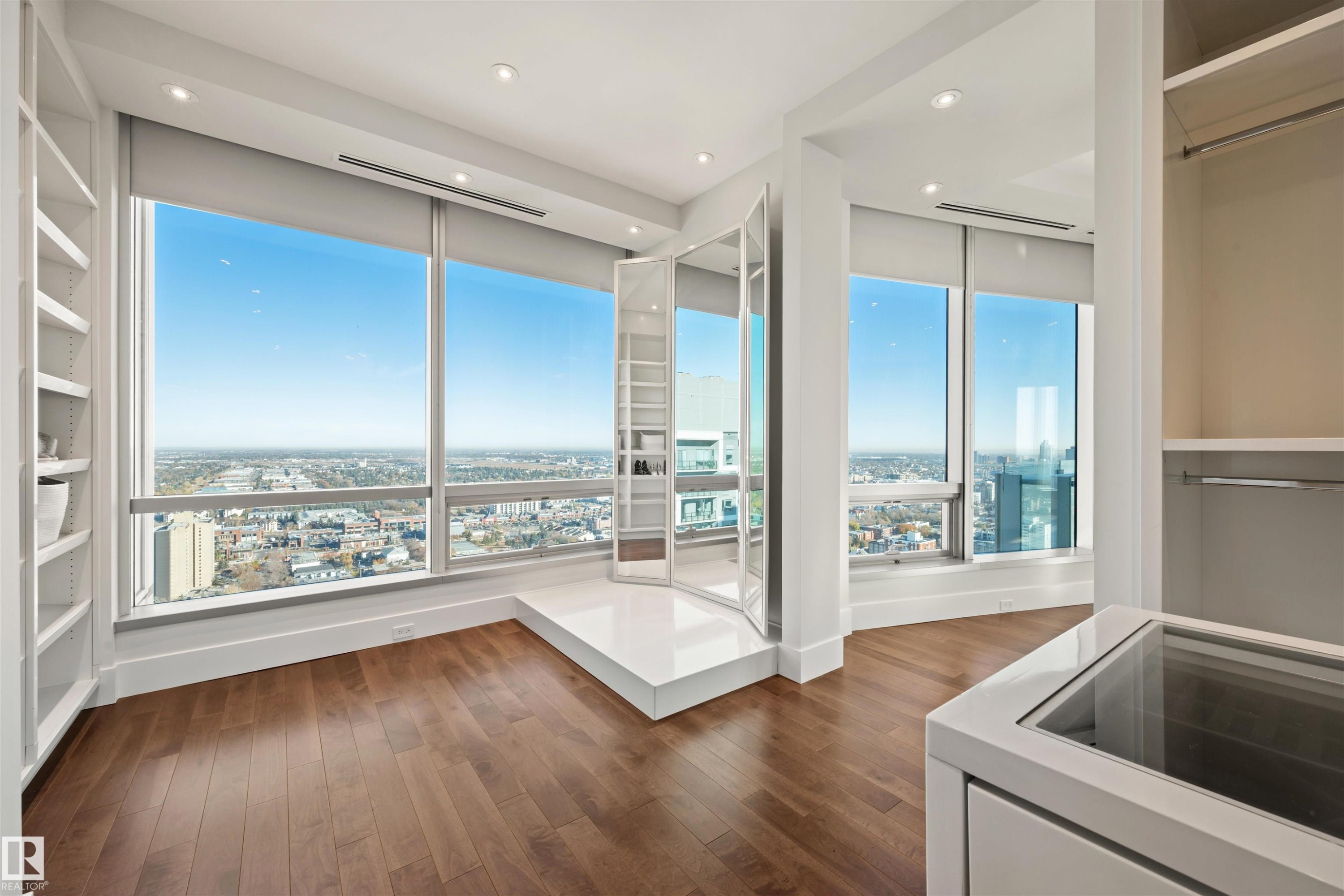 Unfurnished bedroom featuring dark wood finished floors, access to exterior, a view of city, and recessed lighting - 3201 11969 Jasper Avenue, Edmonton, AB - Indoor