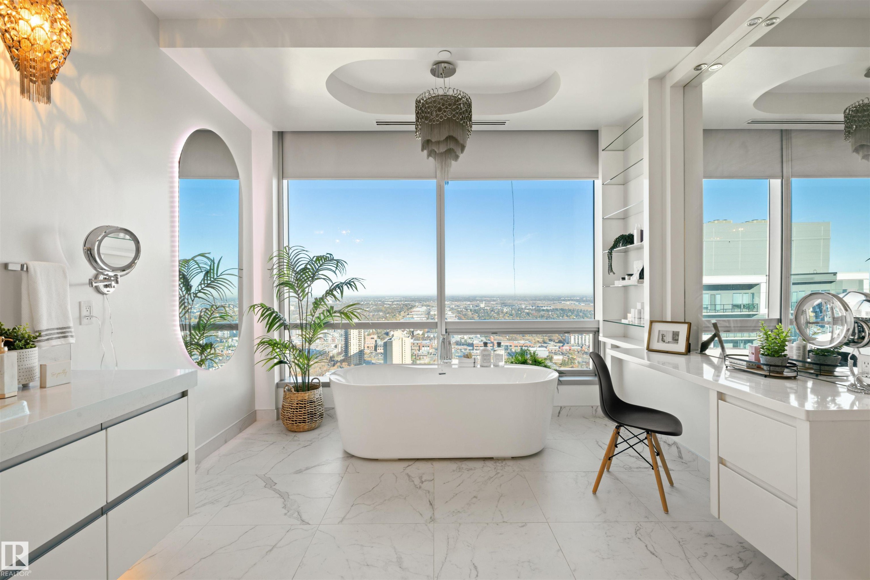 Full bath featuring a freestanding bath, light marble finish floors, a raised ceiling, and vanity - 3201 11969 Jasper Avenue, Edmonton, AB - Indoor