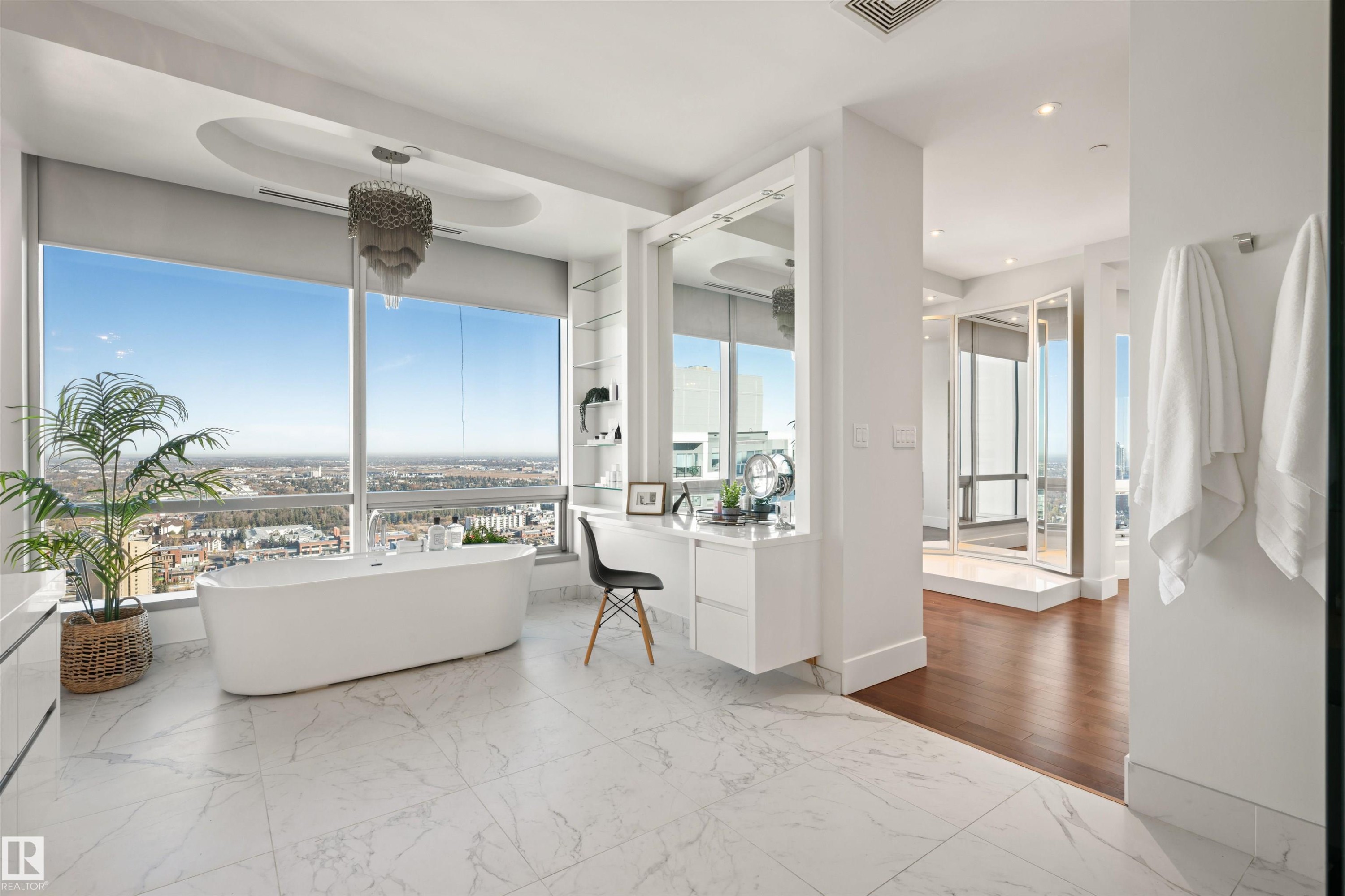 Bathroom featuring light marble finish floors, vanity, a freestanding bath, and recessed lighting - 3201 11969 Jasper Avenue, Edmonton, AB - Indoor