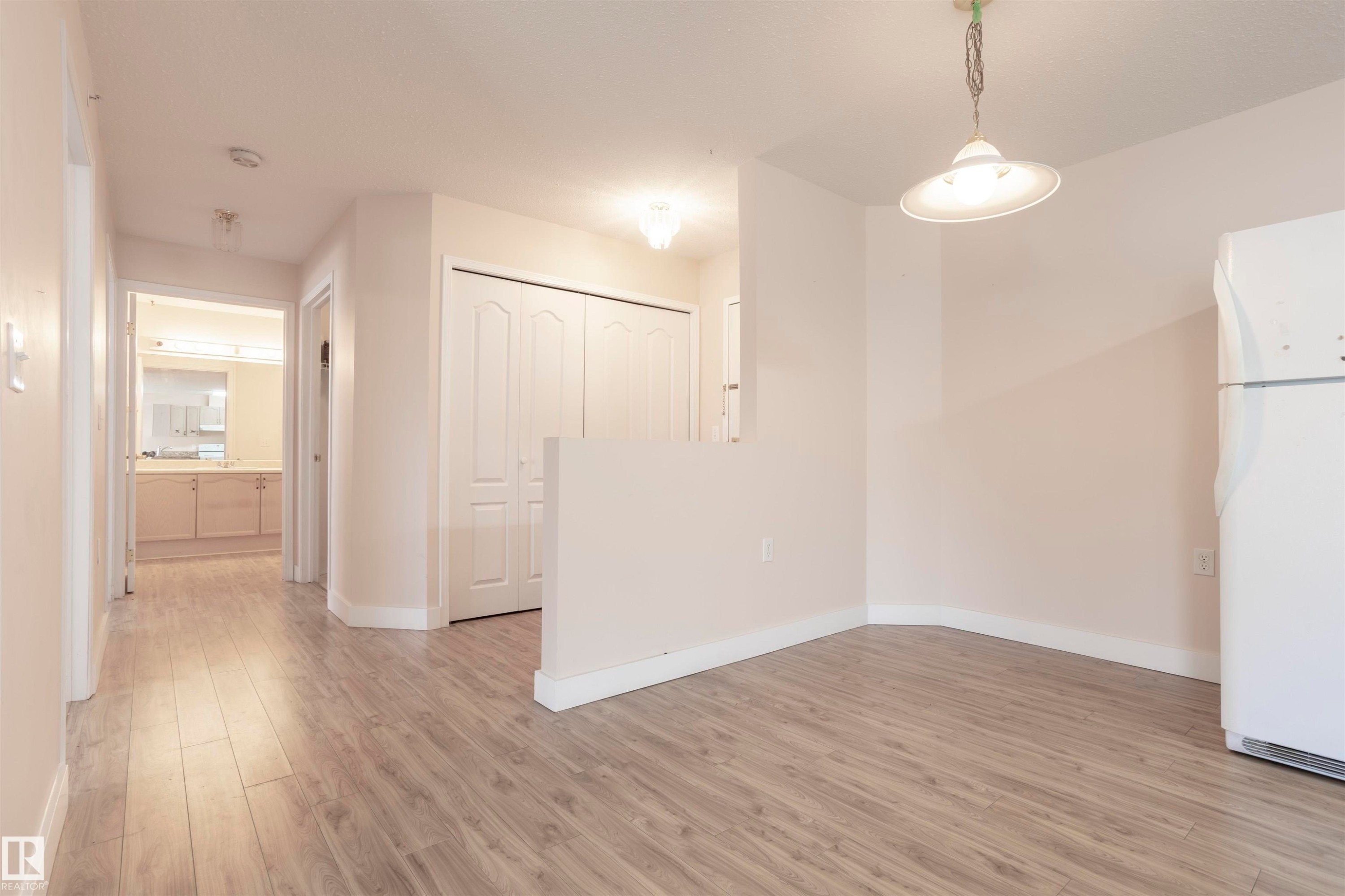 Unfurnished dining area featuring light wood-style floors and baseboards - 262 13441 127 Street, Edmonton, AB - Indoor Photo Showing Other Room