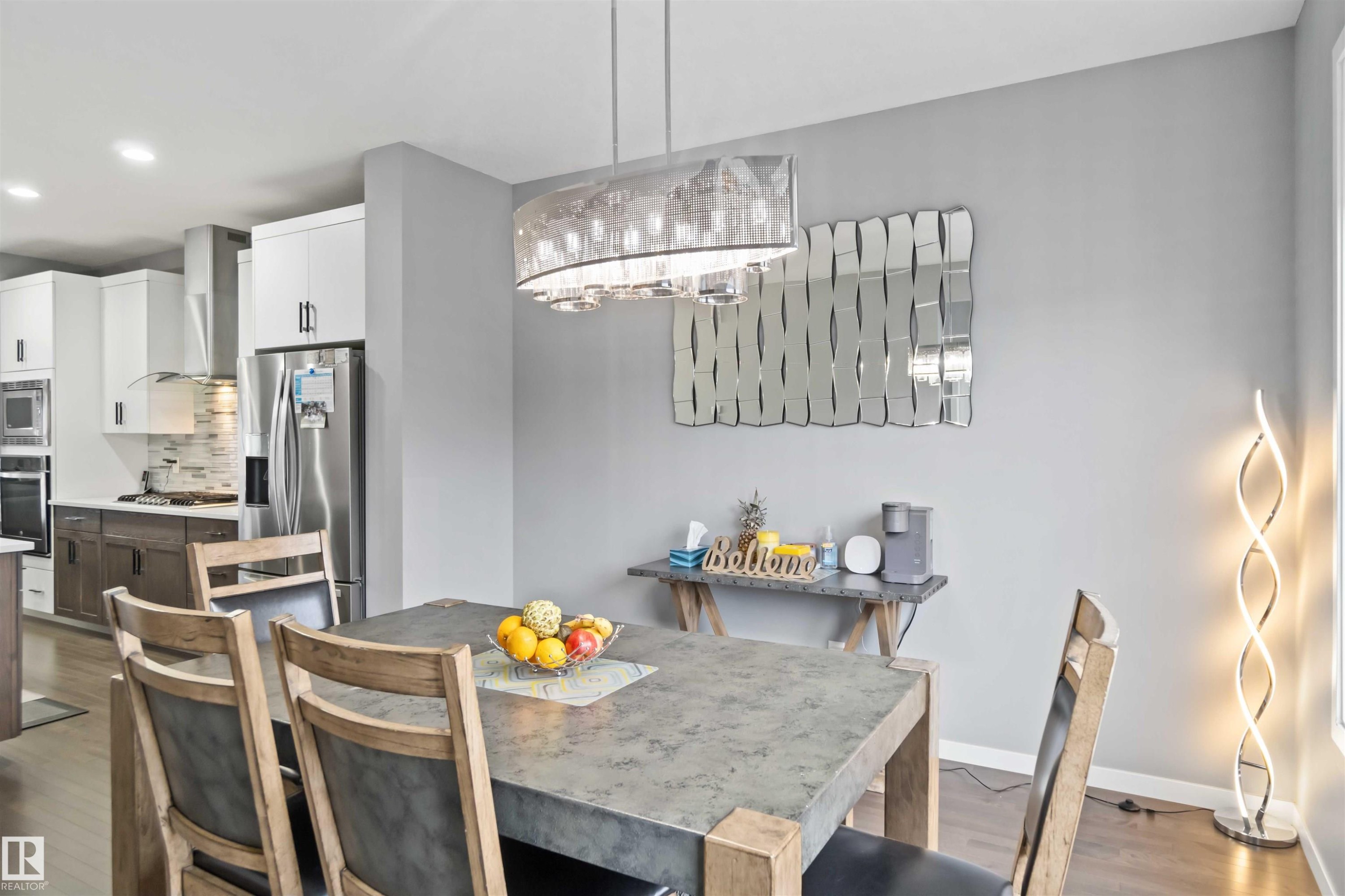 Dining area with dark wood-style flooring, recessed lighting, and a chandelier - 17816 59 Street, Edmonton, AB