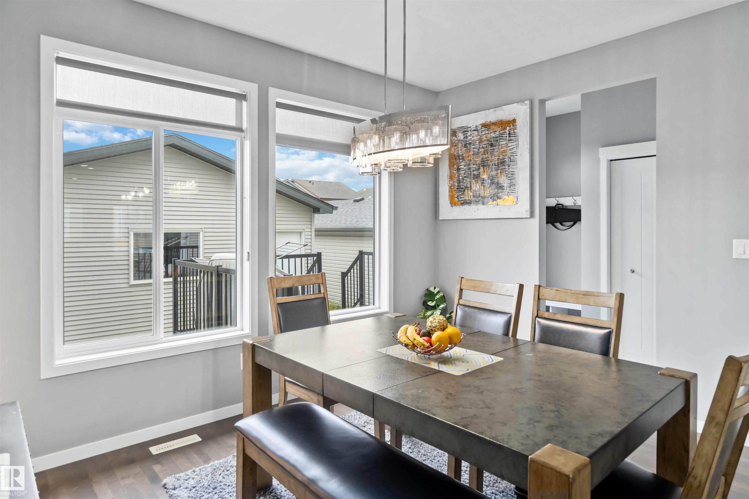 Dining space with dark wood-style floors and a chandelier - 17816 59 Street, Edmonton, AB