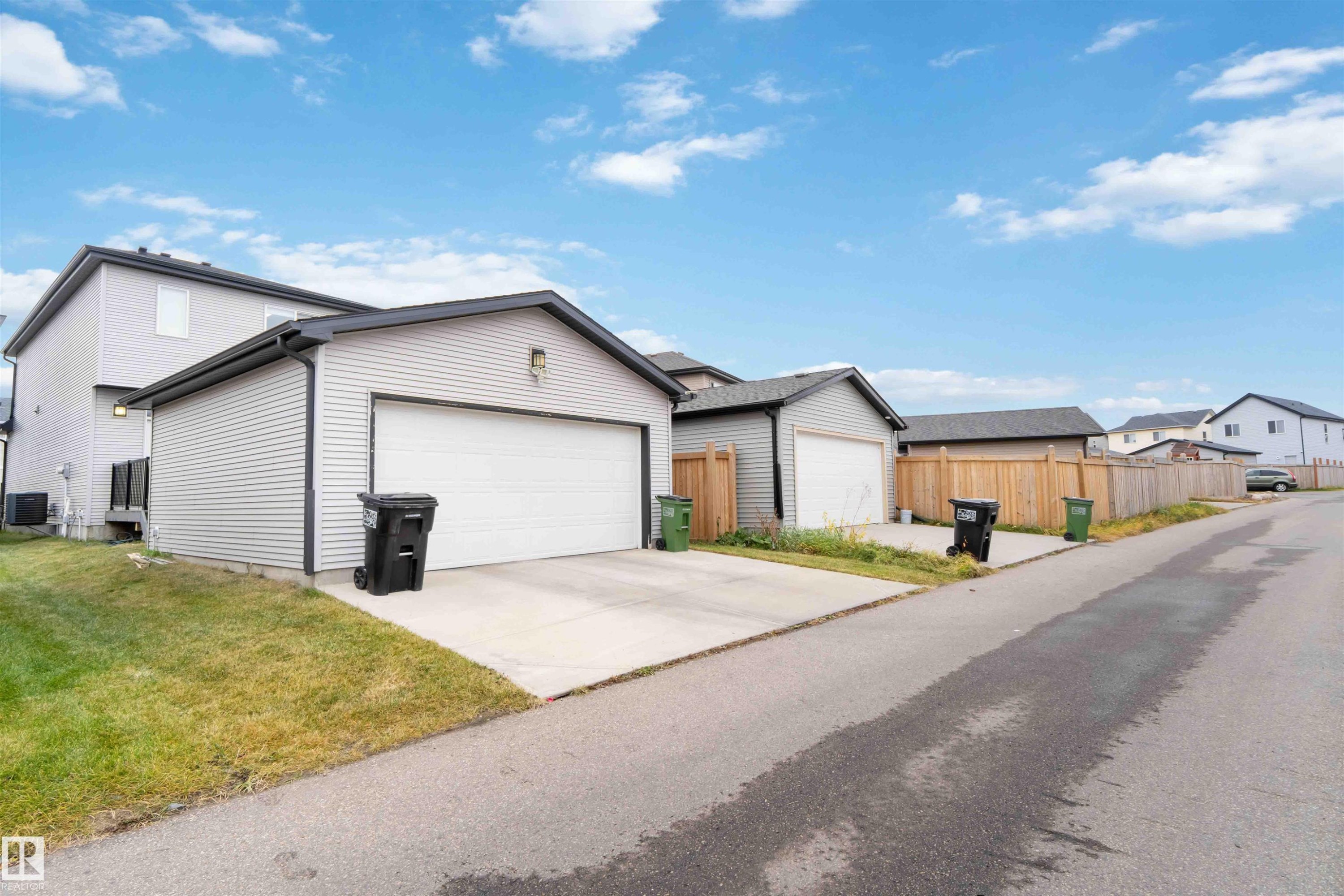 View of front of home featuring an outdoor structure, concrete driveway, and an attached garage - 17816 59 Street, Edmonton, AB