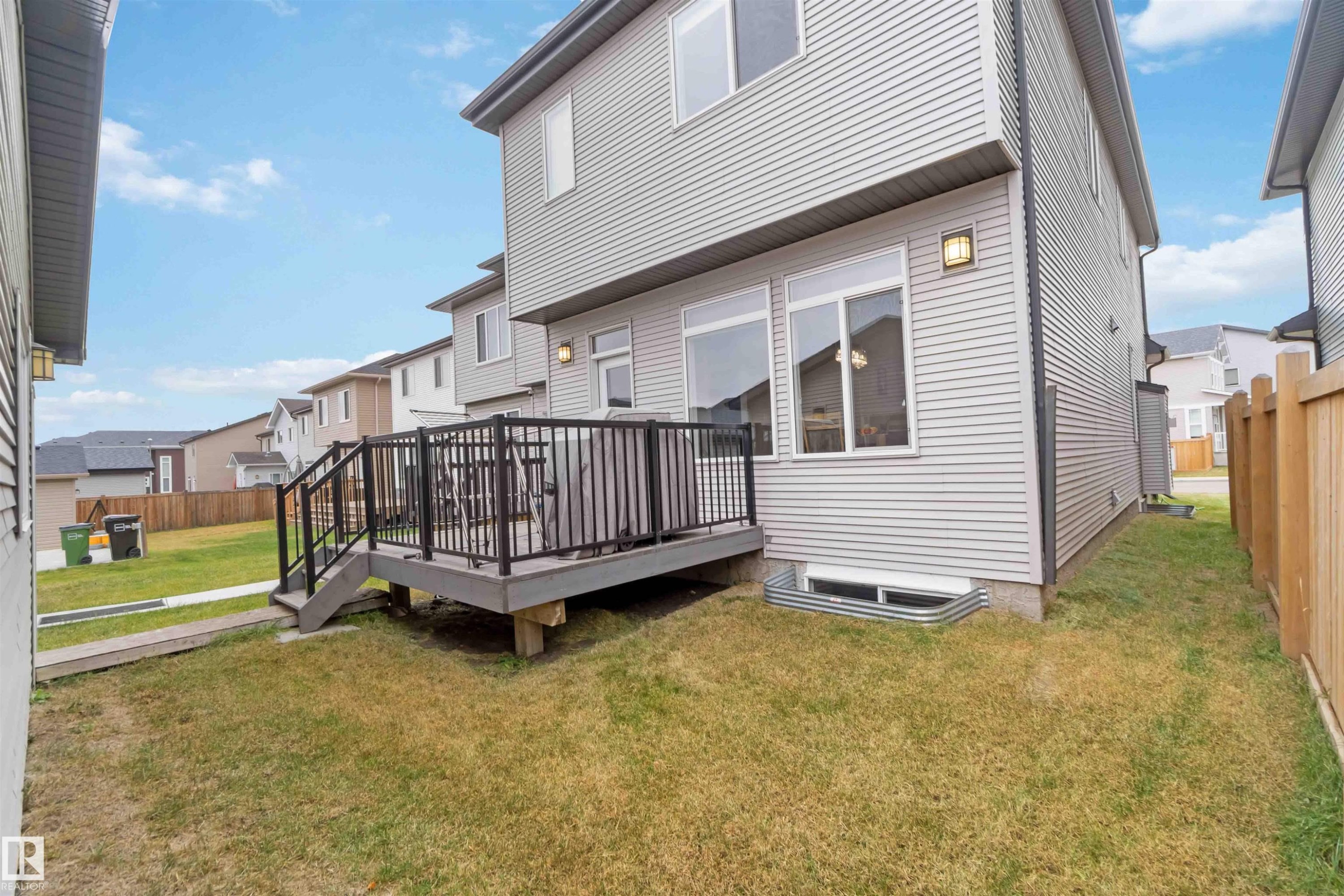 Rear view of house featuring a wooden deck - 17816 59 Street, Edmonton, AB