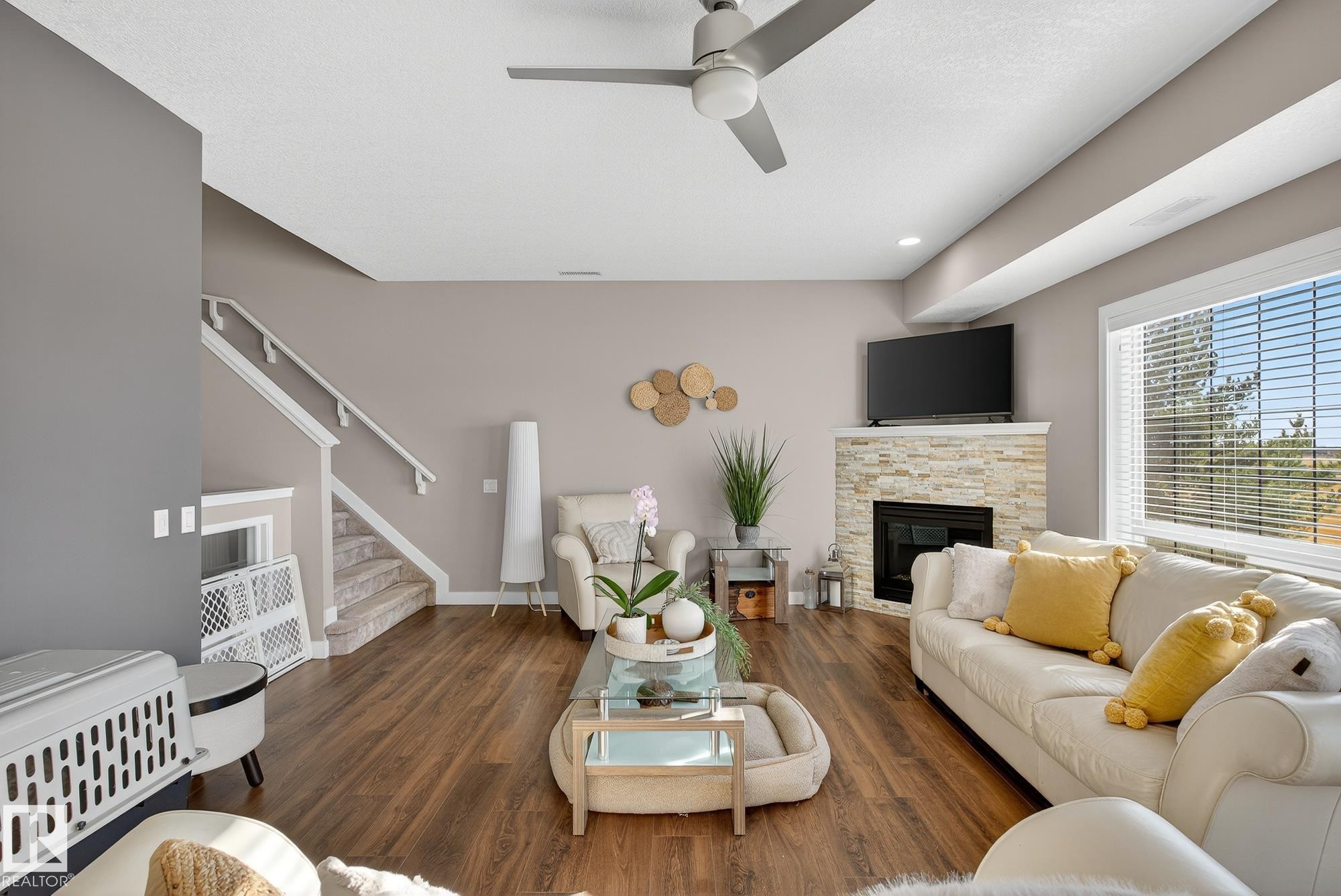 Living area with dark wood finished floors, ceiling fan, a fireplace, stairs, and recessed lighting - 117 7293 South Terwillegar Drive, Edmonton, AB - Indoor Photo Showing Living Room With Fireplace