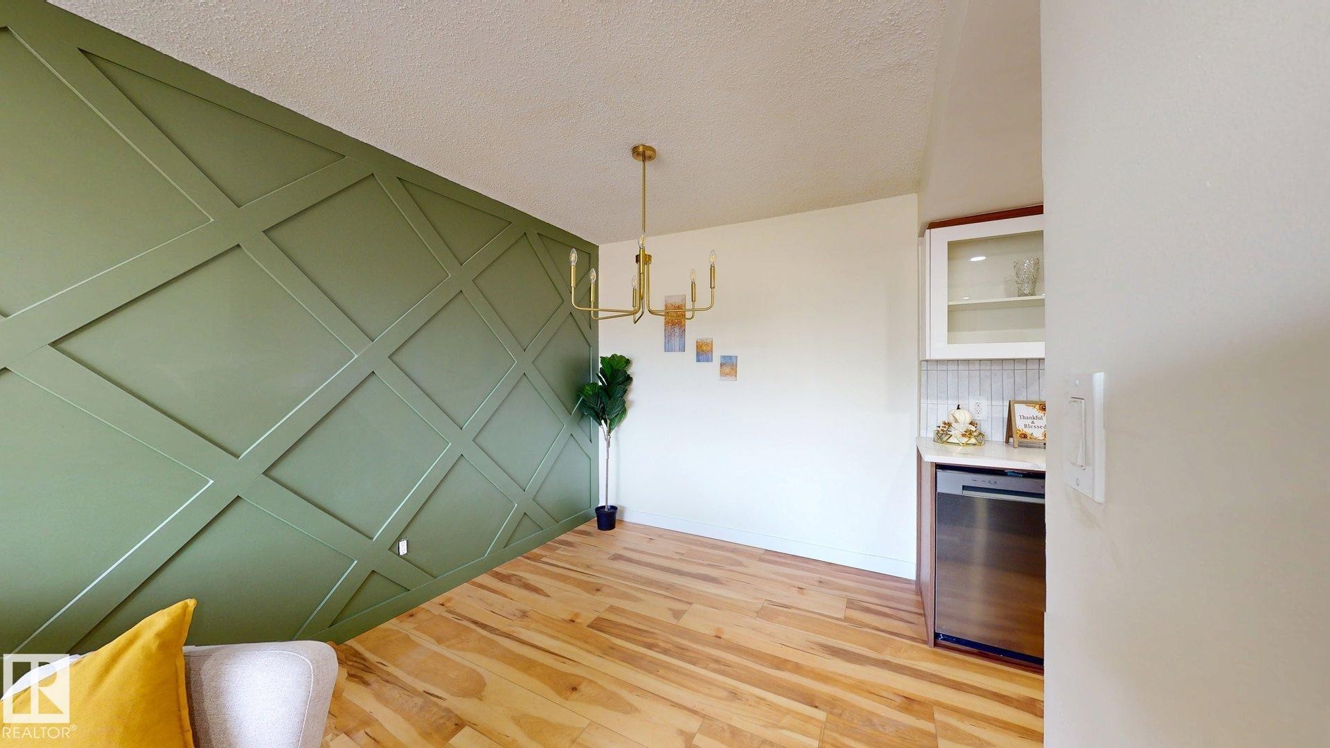Dining room featuring light wood finished floors, a textured ceiling, and a chandelier - 114 2908 116A Avenue, Edmonton, AB - Indoor Photo Showing Other Room