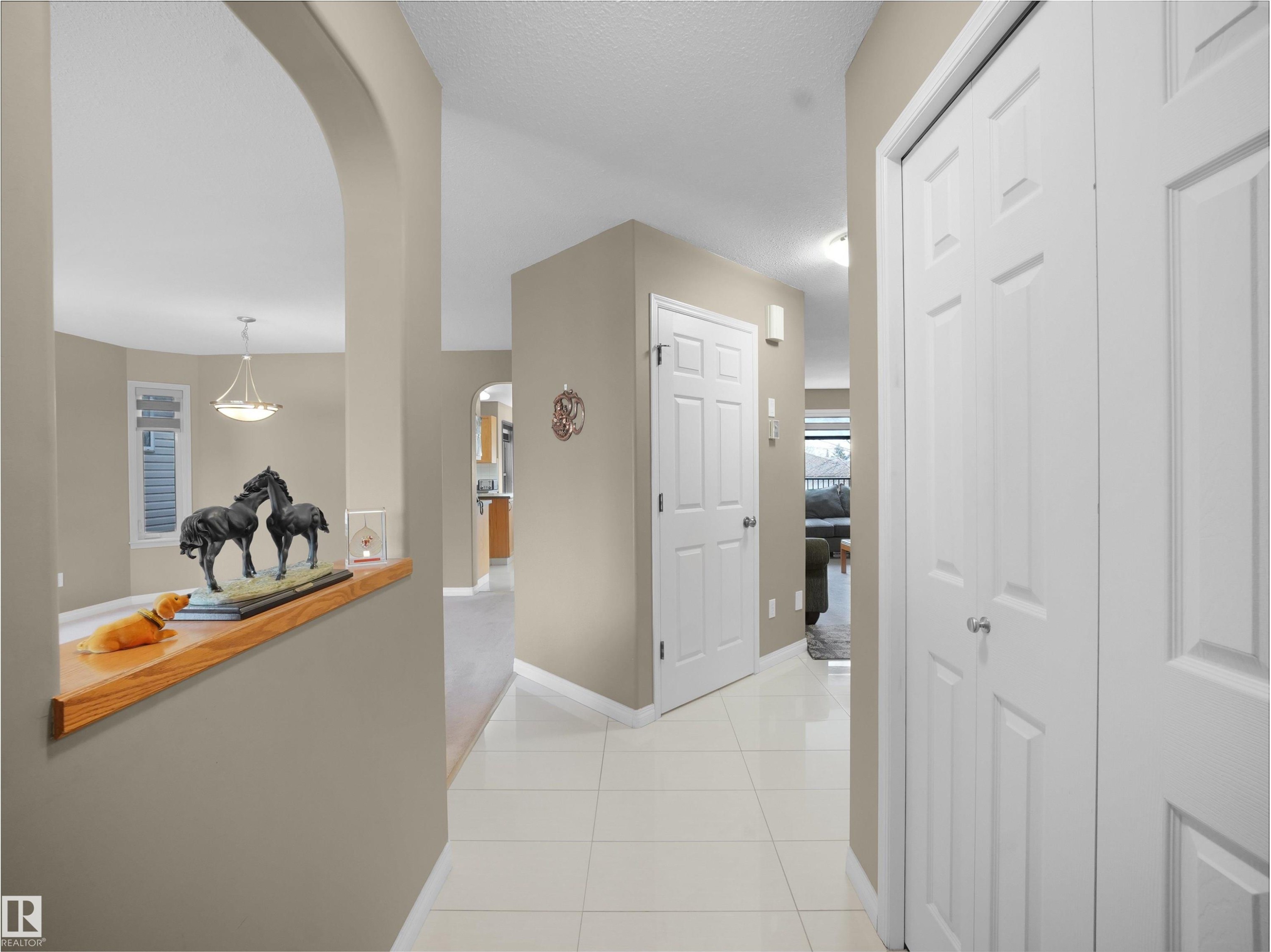 Hallway with arched walkways and light tile patterned floors - 94 Dechene Road, Edmonton, AB - Indoor Photo Showing Other Room