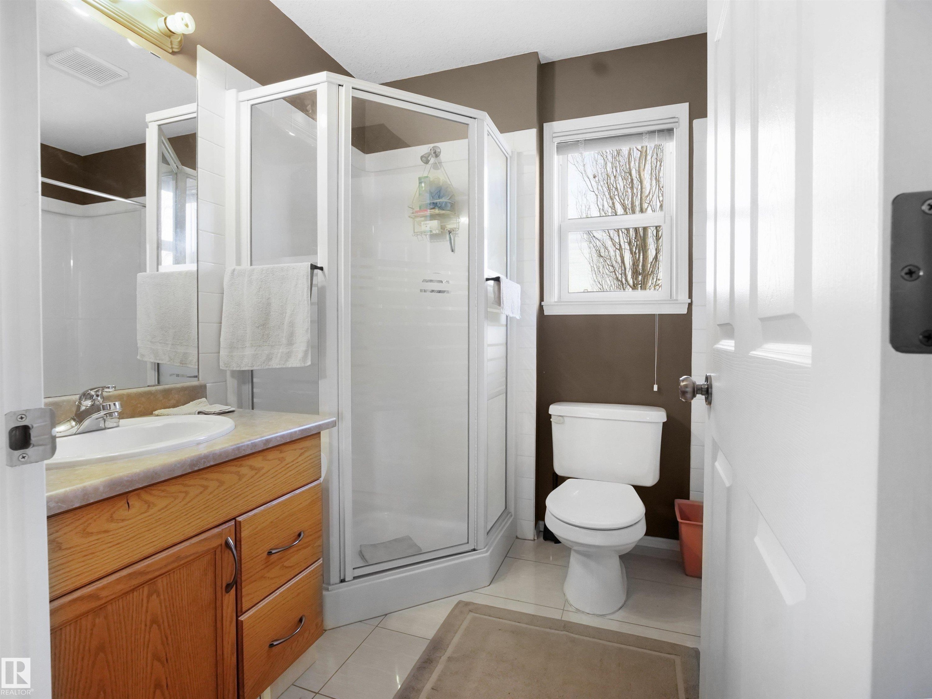 Full bathroom featuring a stall shower, vanity, and light tile patterned floors - 94 Dechene Road, Edmonton, AB - Indoor Photo Showing Bathroom
