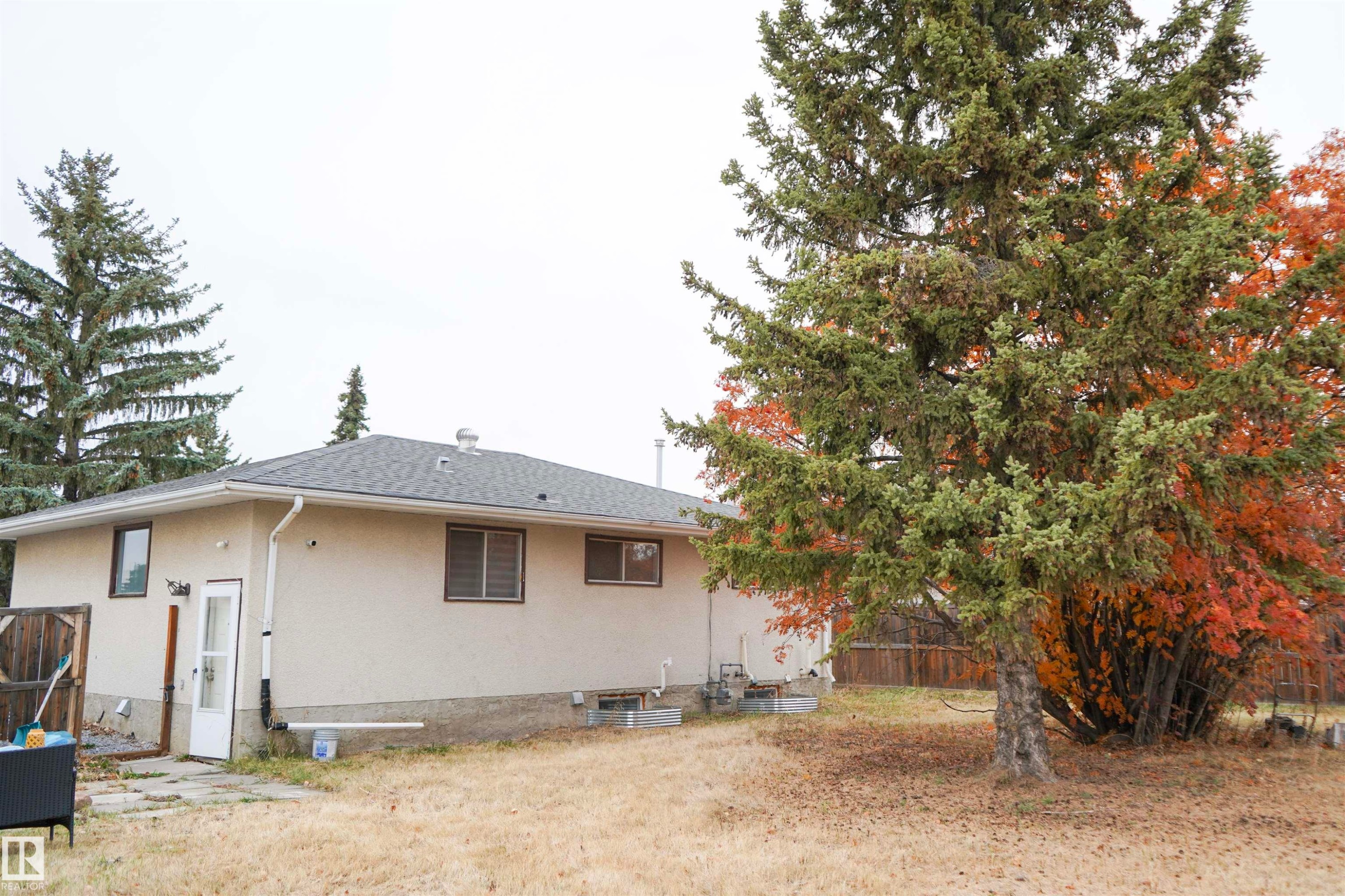 Rear view of property with stucco siding, a patio area, and roof with shingles - 4203 83 Street, Edmonton, AB - Outdoor