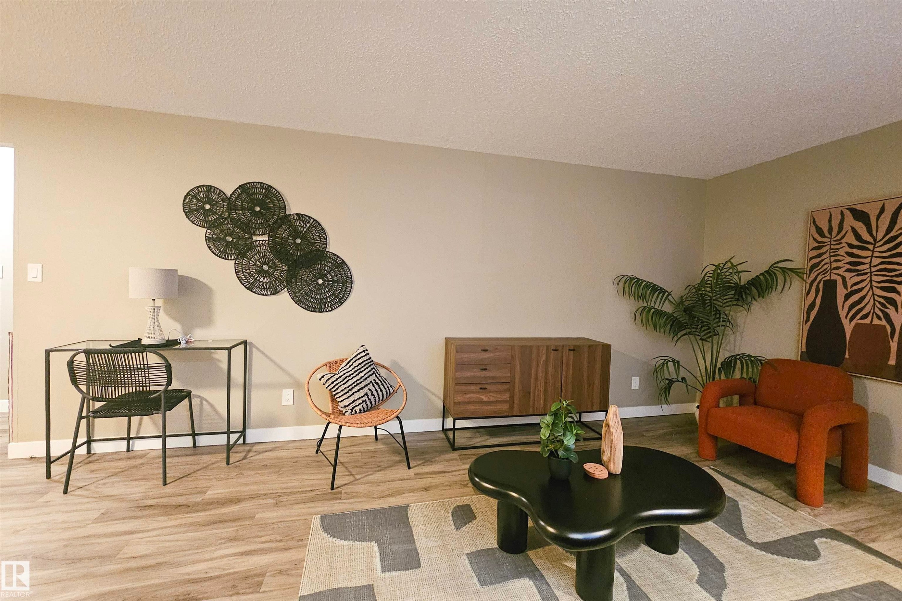 Sitting room with light wood finished floors and a textured ceiling - 4203 83 Street, Edmonton, AB - Indoor