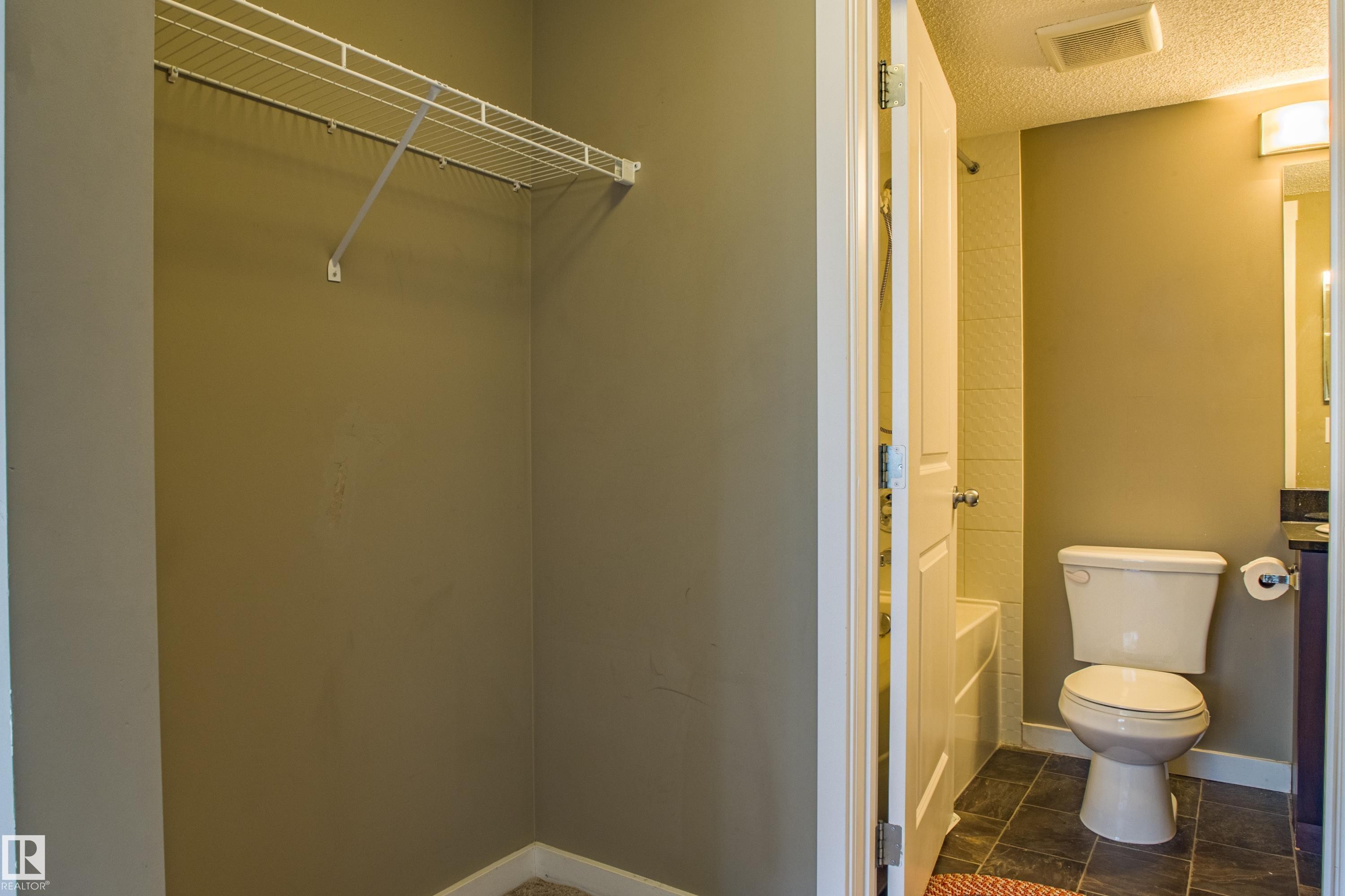 Bathroom featuring a textured ceiling and shower / bath combination - 201 5804 Mullen Place, Edmonton, AB - Indoor Photo Showing Bathroom