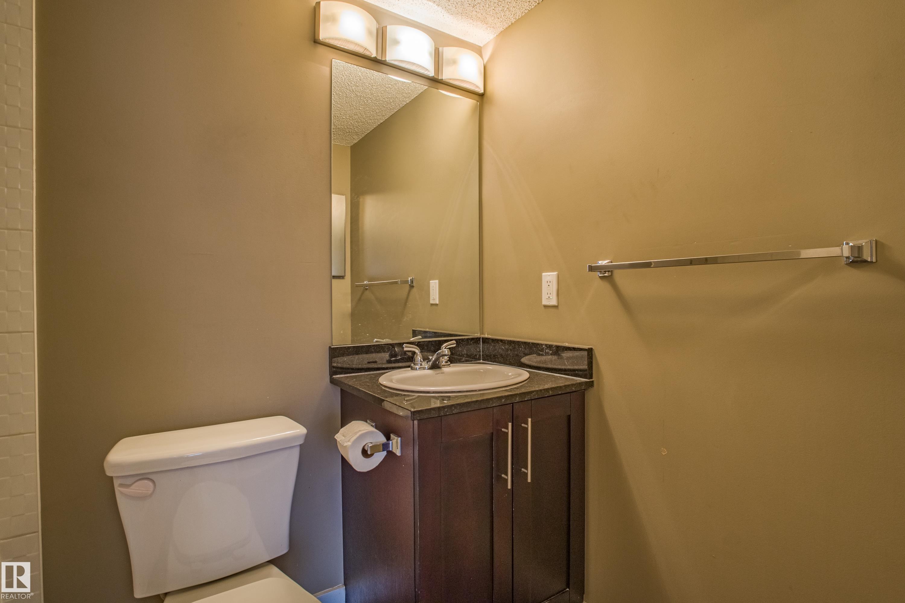 Bathroom with vanity and a textured ceiling - 201 5804 Mullen Place, Edmonton, AB - Indoor Photo Showing Bathroom