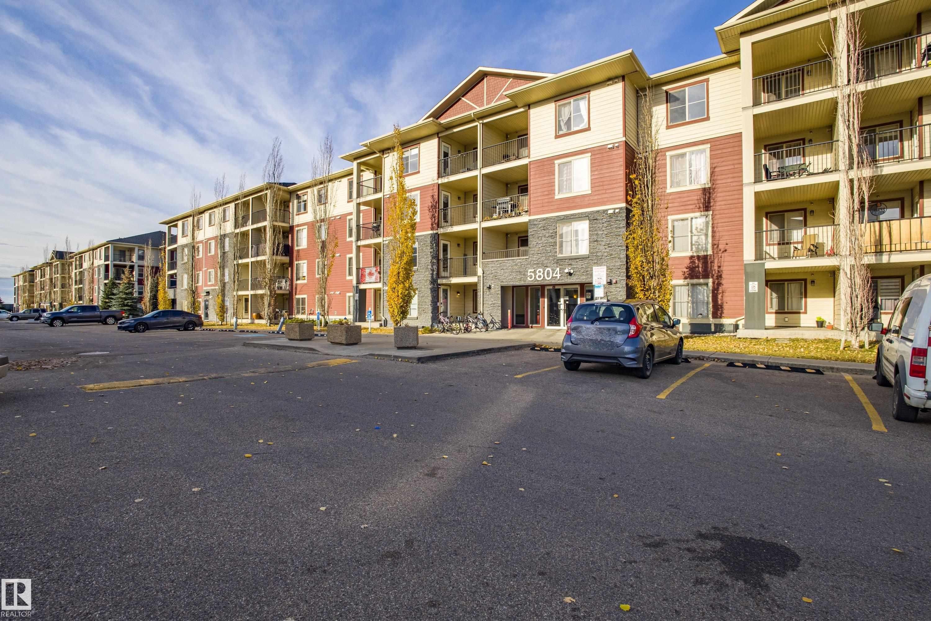 View of apartment building / complex featuring uncovered parking - 201 5804 Mullen Place, Edmonton, AB - Outdoor With Balcony With Facade