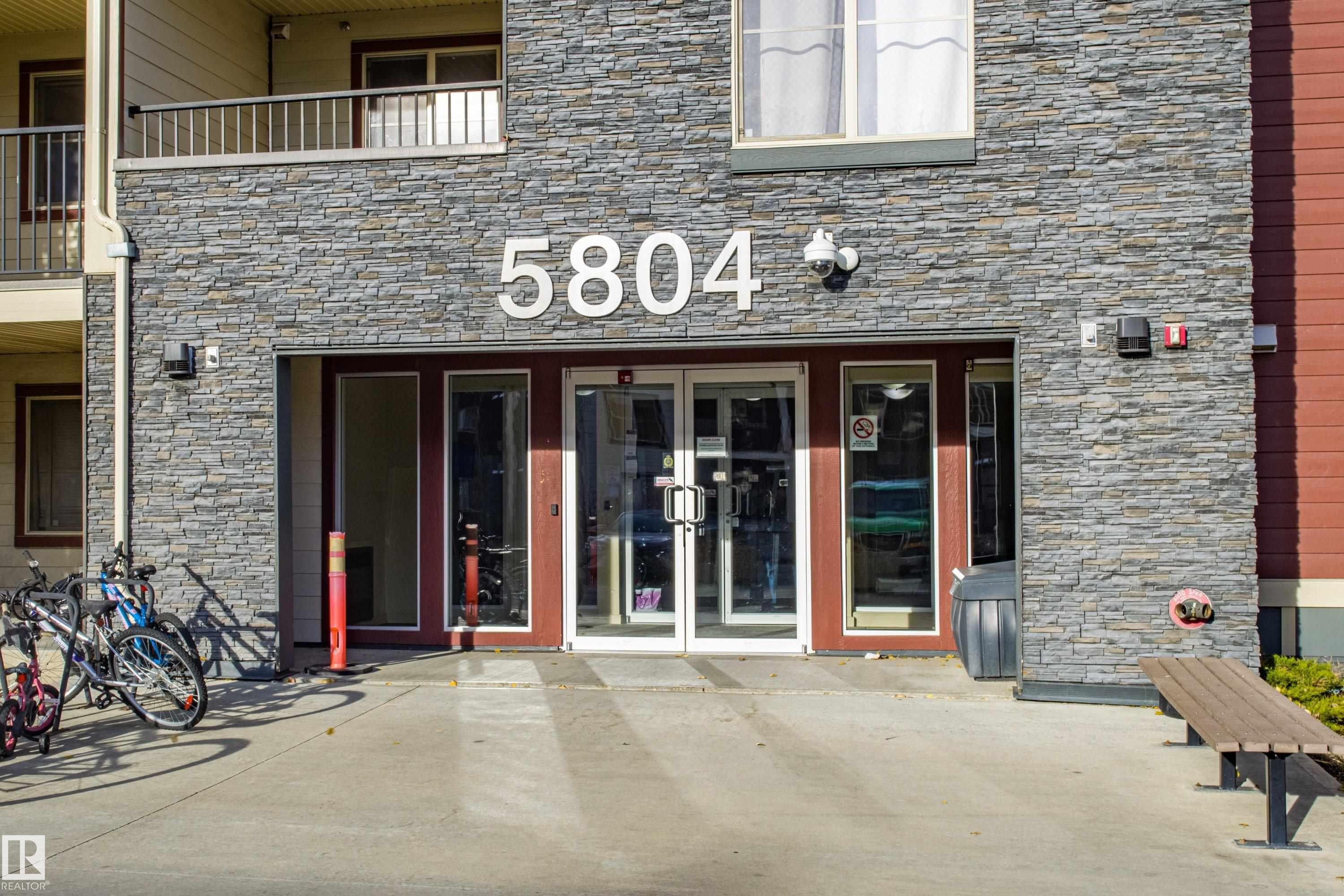 Property entrance with stone siding, french doors, and a patio area - 201 5804 Mullen Place, Edmonton, AB - Outdoor