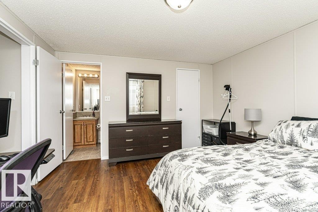 Bedroom featuring dark wood-style floors and a textured ceiling - 1637 68 Avenue, Edmonton, AB - Indoor Photo Showing Bedroom