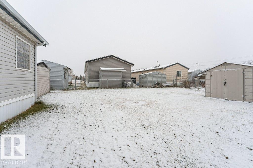 Snowy yard featuring a storage unit and a garage - 1637 68 Avenue, Edmonton, AB - Outdoor With Exterior
