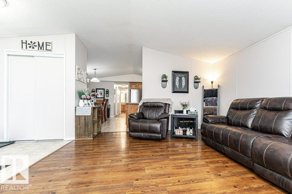 Living room featuring lofted ceiling, light wood-style flooring, and a textured ceiling - 1637 68 Avenue, Edmonton, AB - Indoor Photo Showing Living Room